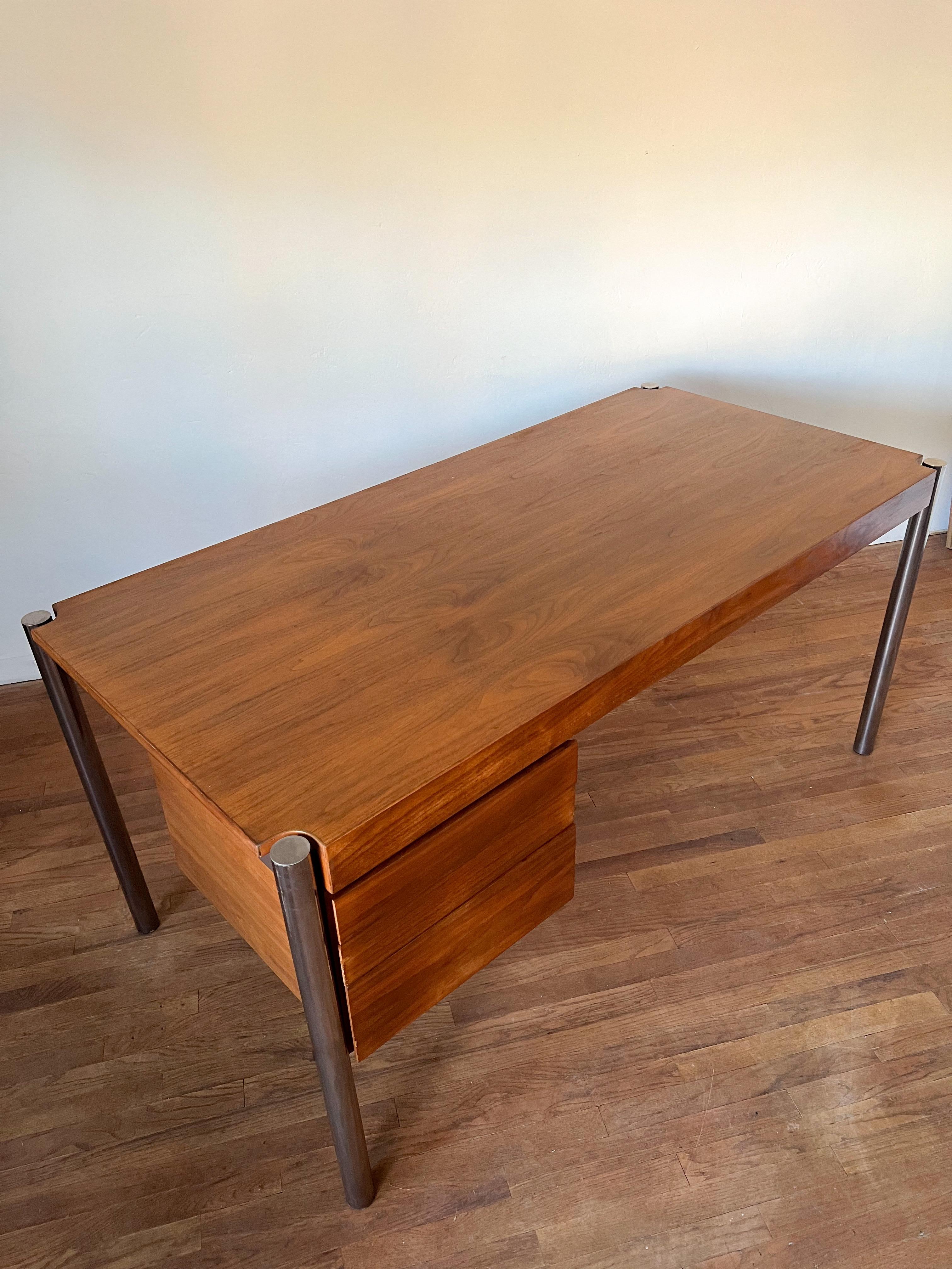 Beautiful executive desk designed by Jens Risom and manufactured by Howe Furniture in the 1970s. This desk features an elegantly broad top with three spacious drawers in walnut, resting on very minimalistic and sculptural chrome legs that appear to