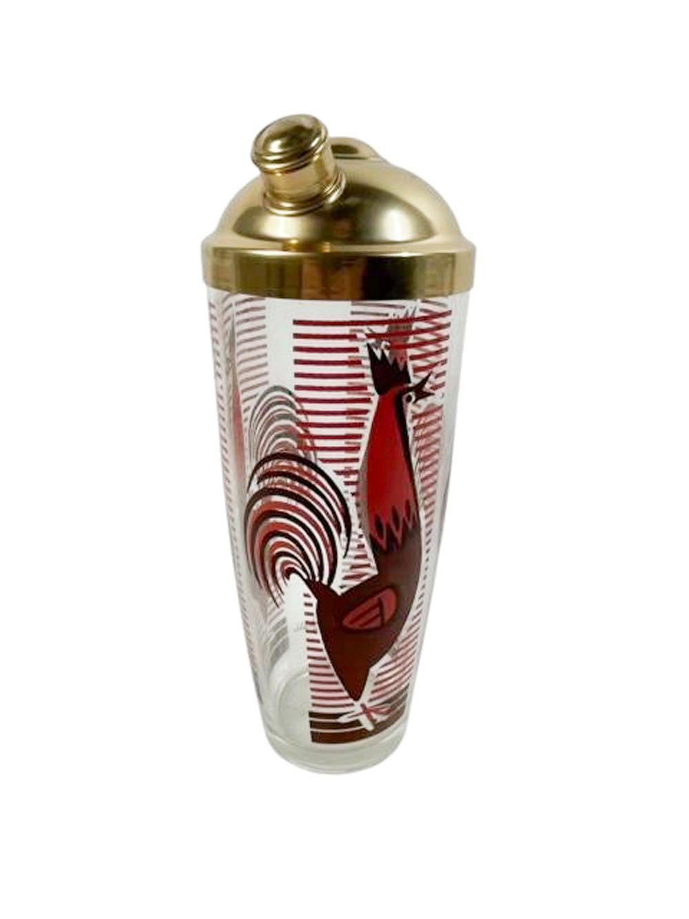 Clear class cocktail shaker with gold-tone cover, the glass decorated with large, stylized roosters in brown and orange enamel against a ground of horizontal bars repeated three times around the shaker and signed 