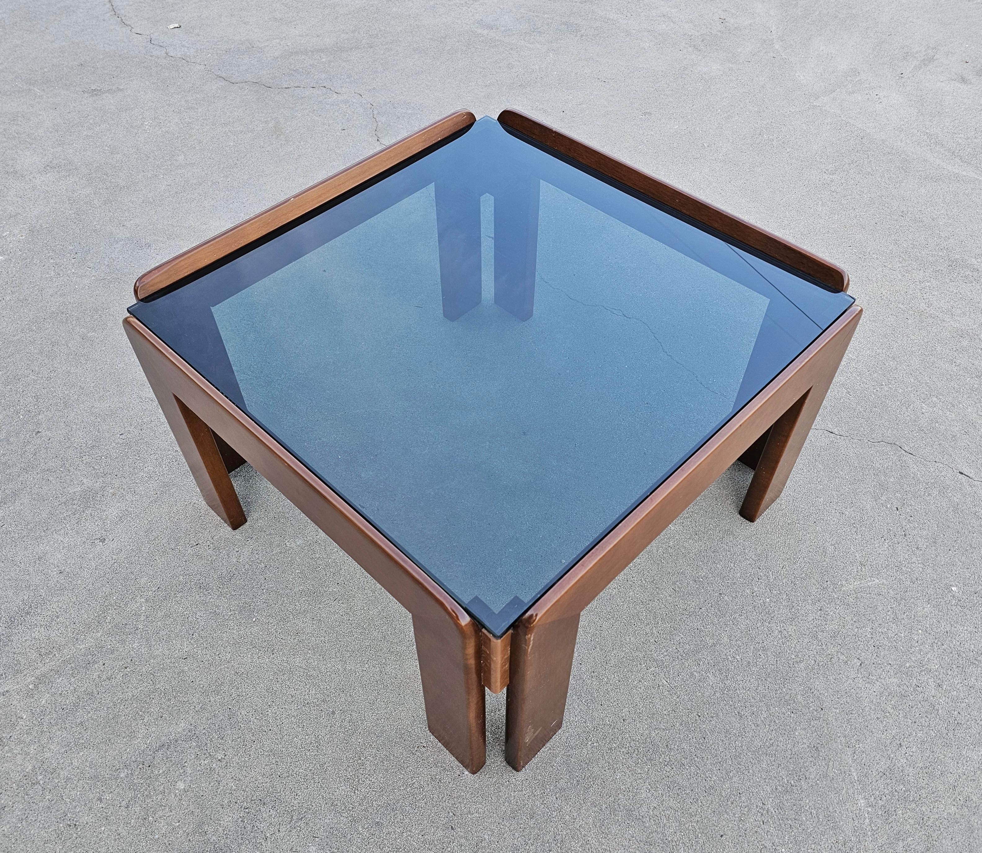 In this listing you will find a very rare Mid Century Modern coffee table designed by Afra and Tobia Scarpa, the Italian duo who is behind some of the most iconic pieces of Mid Century design. The coffee table is done in walnut, with smoked glass
