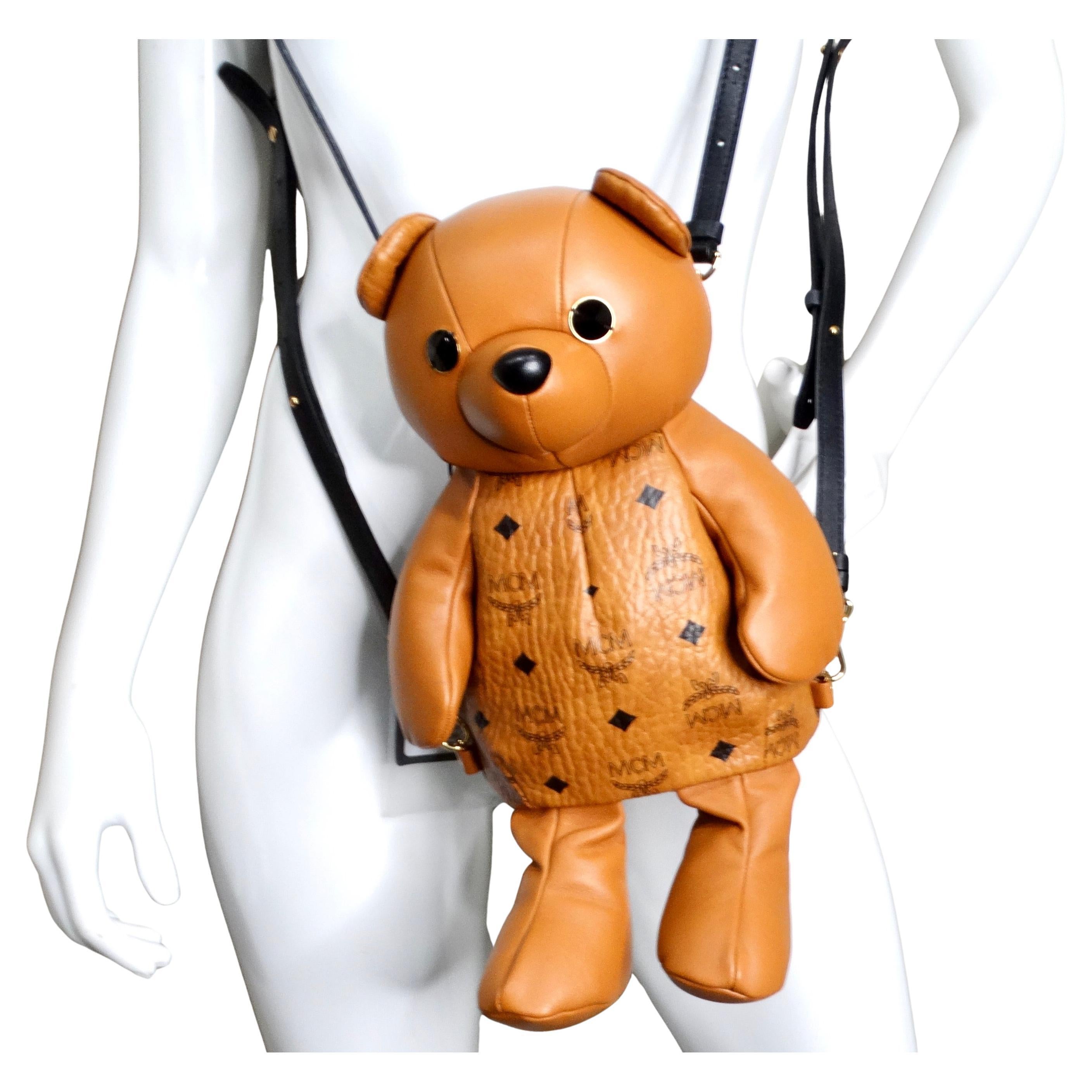 La Mochila MCM Visetos Bear Zoo Doll de piel de becerro coñac es un accesorio caprichoso y lujoso que combina un diseño juguetón con una artesanía de alta gama. Confeccionado en piel de becerro de color coñac, el bolso presenta el icónico monograma