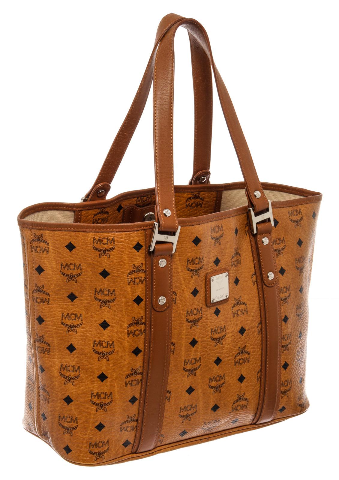 MCM Shopper tote bag is crafted from cognac Visetos coated canvas and brown leather. This shopper tote is held by dual flat handles, complete with silver-tone hardware and comes with a spacious light brown woven canvas interior lining meant to hold