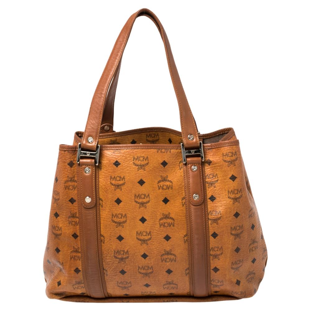 A creation that is both highly functional and appealing is this tote by MCM. Crafted from Visetos coated canvas and leather, this shopper tote is held by dual handles and comes with a spacious interior meant to hold your essentials with
