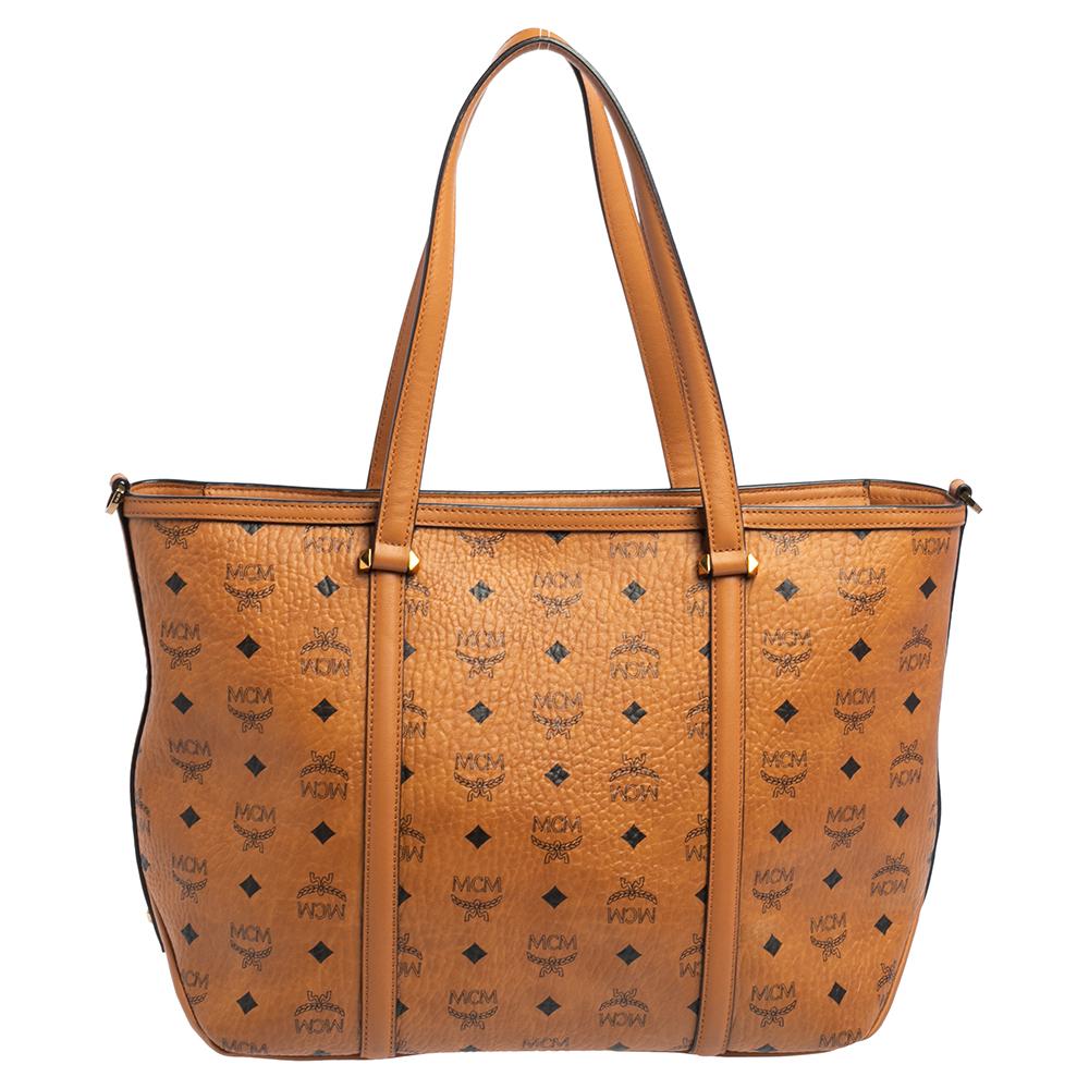 A creation that is both highly functional and appealing is this tote by MCM. Crafted from Visetos coated canvas and leather, this shopper tote is held by dual handles and comes with a spacious interior meant to hold your essentials with ease.