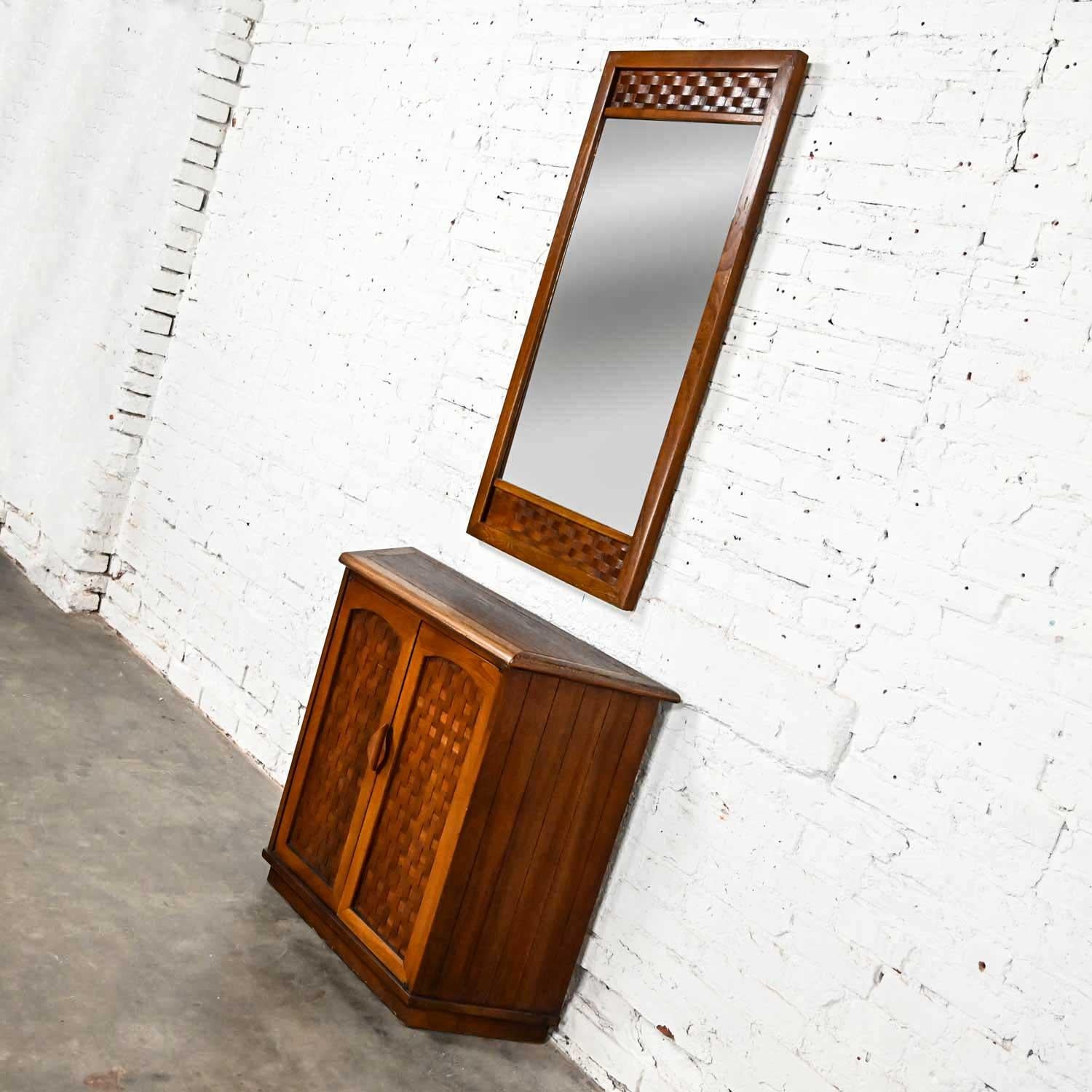 Handsome two-piece set comprised of an entry console cabinet and matching mirror with basket weave detail done in the style of Lane Furniture from their Perception line designed by Warren C. Church. These pieces do not have a Lane tag or mark.