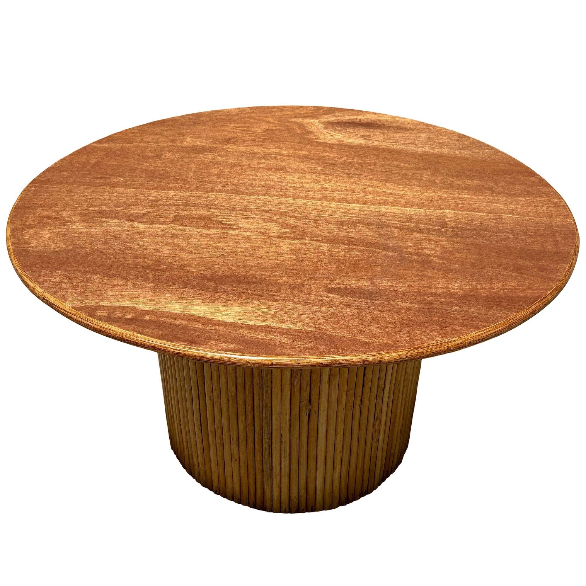 Cette table minimaliste mais élégante, magnifiquement restaurée, présente une colonne de rotin empilée verticalement formant un piédestal avec un plateau rond de 36 pouces en acajou avec une bordure en rotin. Tous sont méticuleusement remis à neuf