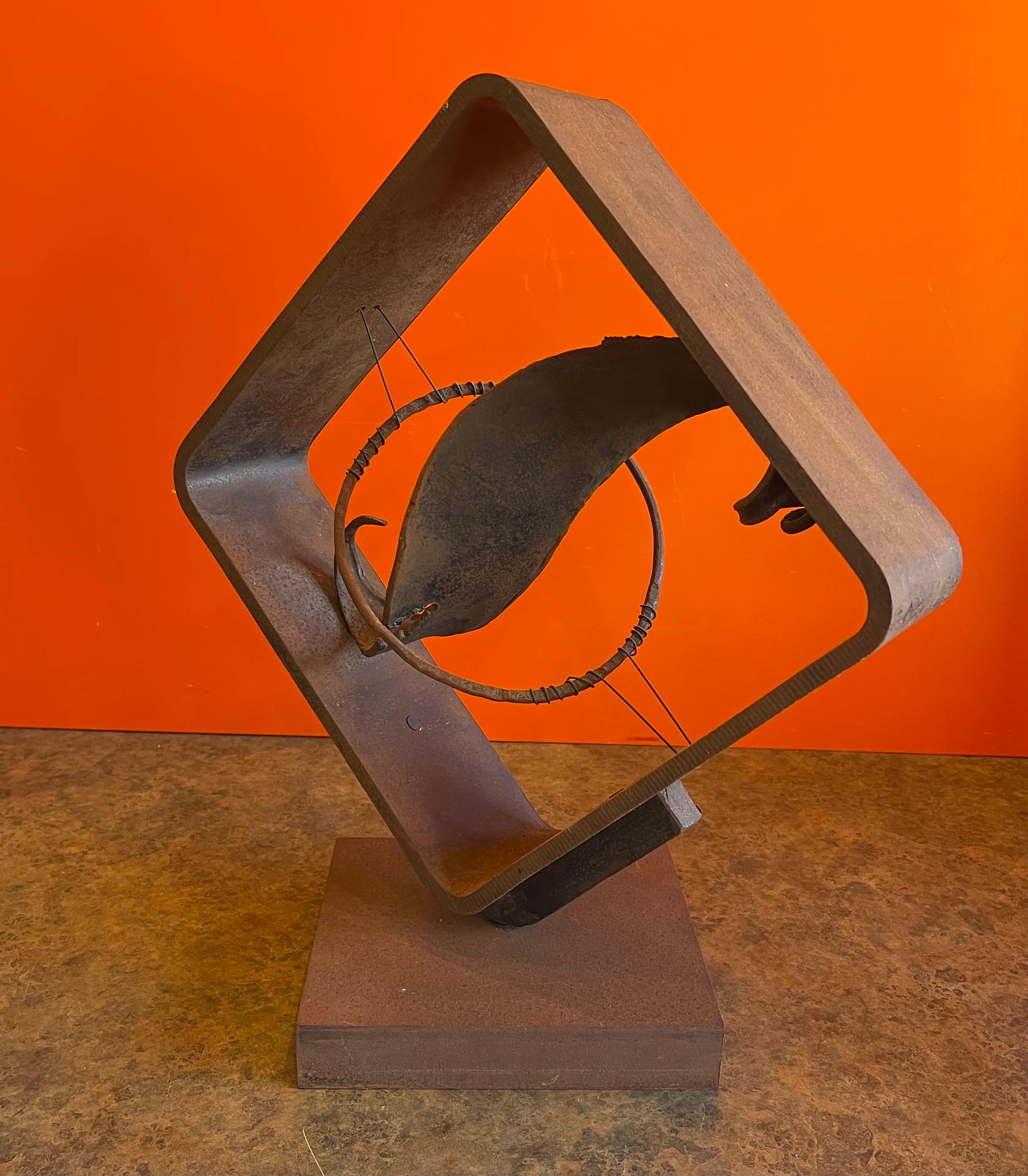 A very cool MCM cut steel rotating abstract sculpture by James Hubbell, circa 1970s. The sculptural piece is made of dark cut steel that is welded into a diamond shape on a heavy steel base. The piece is in good condition with a vintage patina and