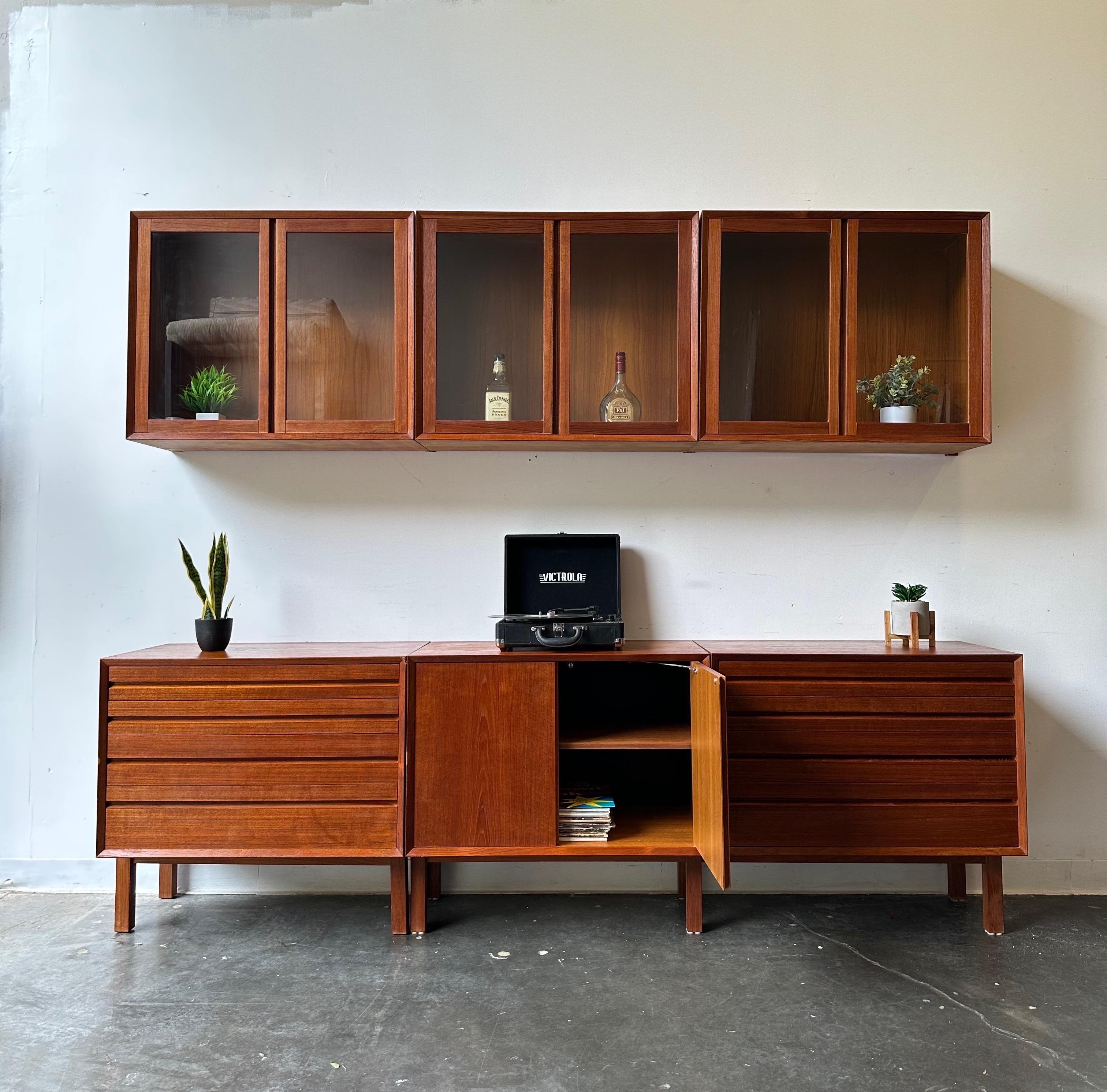 Wall Unit by Poul Cadovius for Cado

Gorgeous teak Modular wall unit.
Includes three floating glass door shelves with brackets and three bottom cabinets ( one open hutch with shelf and two drawer units ) sitting on a cado floor stand.

This unit is