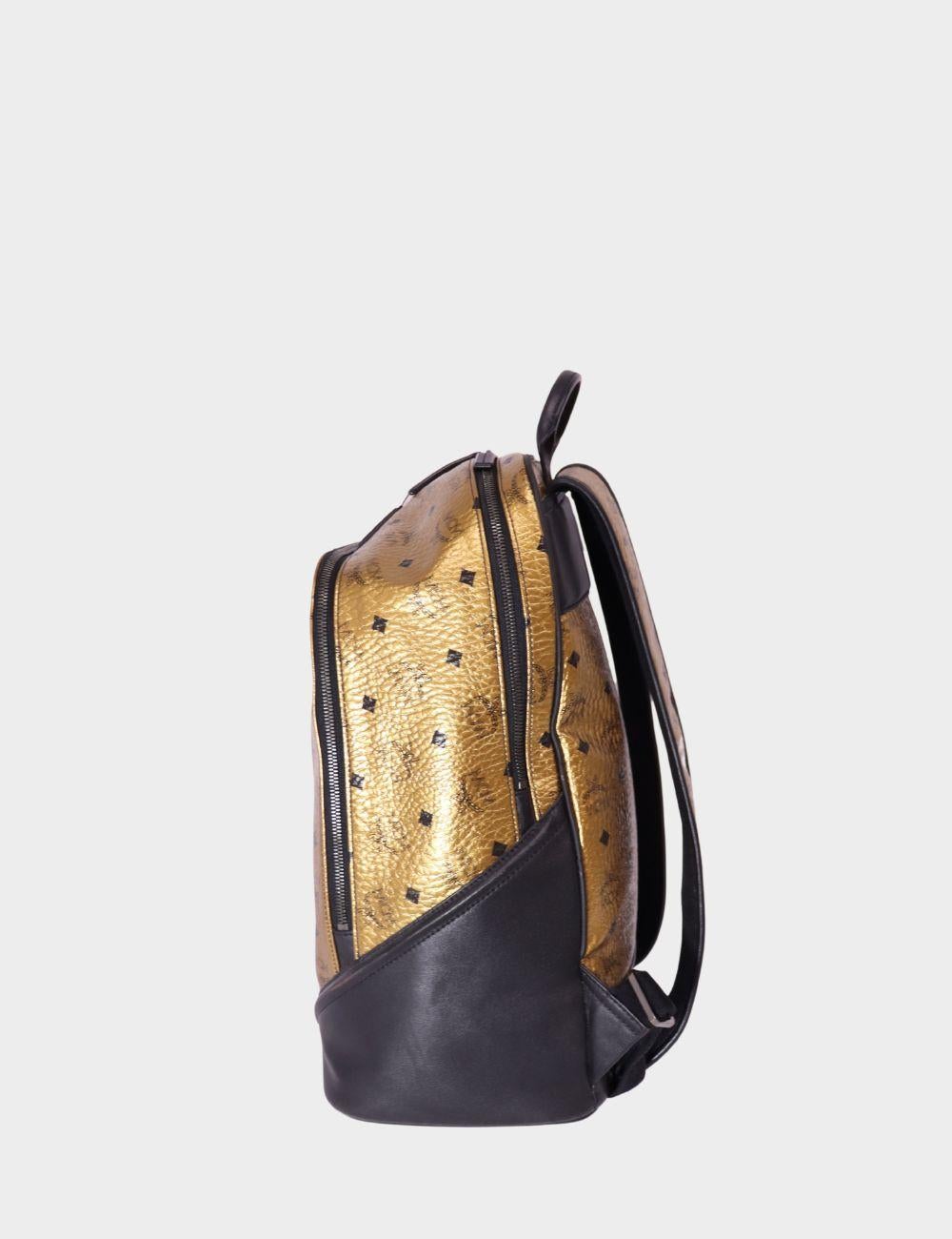 Haz una declaración atrevida con esta mochila MCM Stark en la icónica lona dorada recubierta de Visetos. Con el característico estampado del monograma de MCM, esta mochila estructurada está acentuada con un elegante ribete de piel negra para lograr