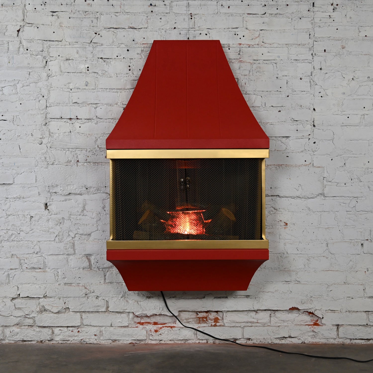 Incredible vintage Mid-Century Modern electric wall fireplace square orange frame with gold tone trim, artificial logs, and solid brass screens attributed to Montgomery Ward Style House Fireplace. This piece has been attributed based upon archived