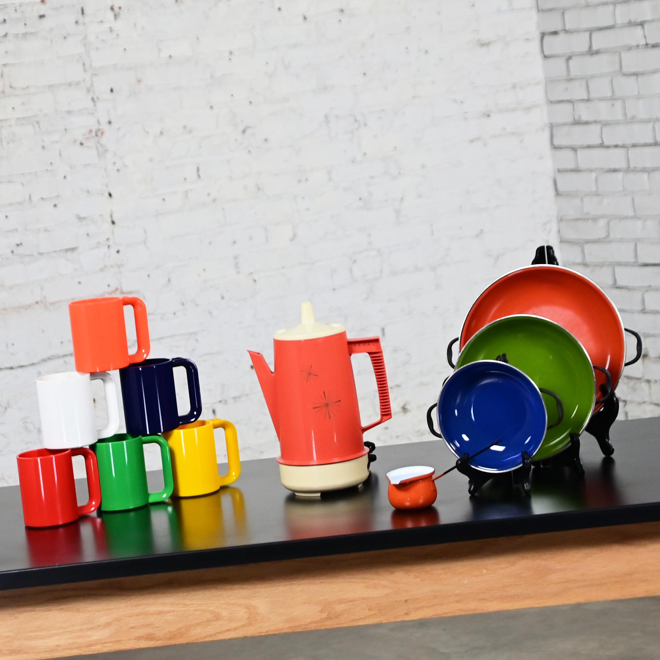 Fabelhaftes Vintage-Set aus 3 emaillierten Kochgeschirren von Emo Celje Jugoslawien, einer orangefarbenen Regal Poly Perk Kaffeemaschine und sechs mehrfarbigen Plastikbechern von Ingrid. Schöner Zustand, im Auge behalten, dass diese sind Vintage und