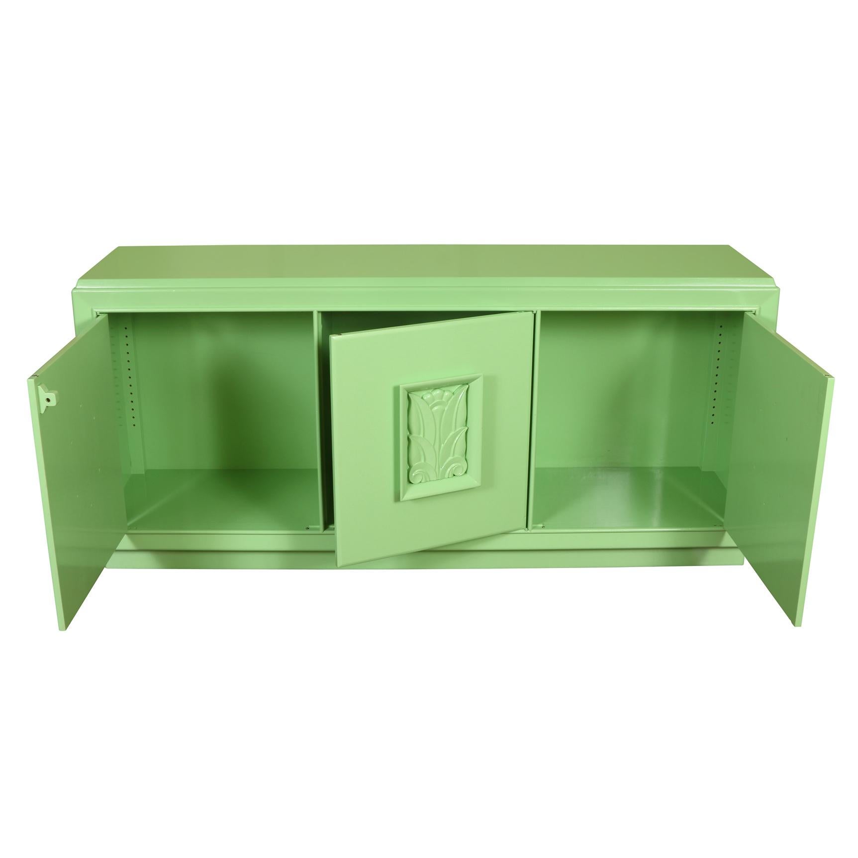 Mid-Century Modern three door green lacquered credenza. Each door is decorated with carved palm leaf relief.