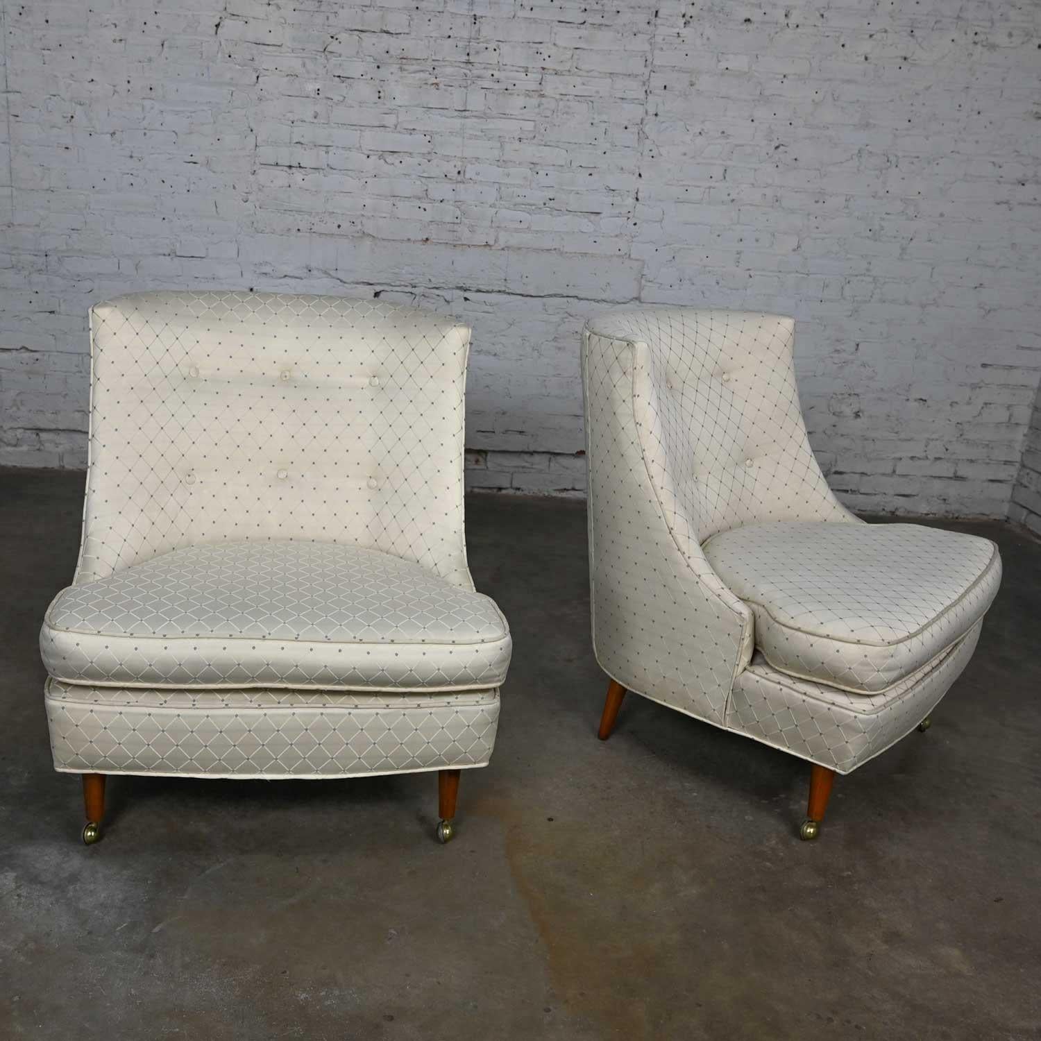 Gorgeous vintage MCM aka Mid-Century Modern or Hollywood Regency button back oyster & blue colored harlequin fabric slipper chairs with front brass ball casters. Beautiful condition, keeping in mind that these are vintage and not new so will have