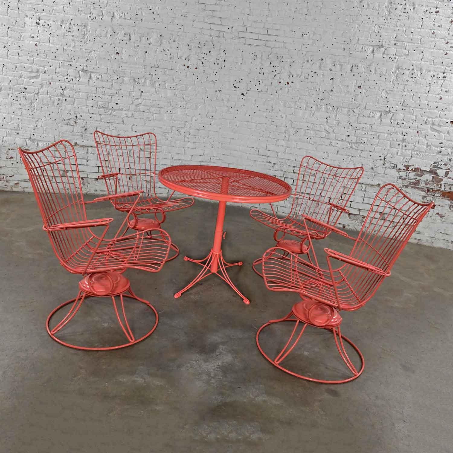 Wonderful vintage Homecrest outdoor coral painted height adjustable dining, coffee, or end table with round expanded metal mesh top and 4 metal wire springer chairs. Beautiful condition, keeping in mind that these are vintage and not new so will
