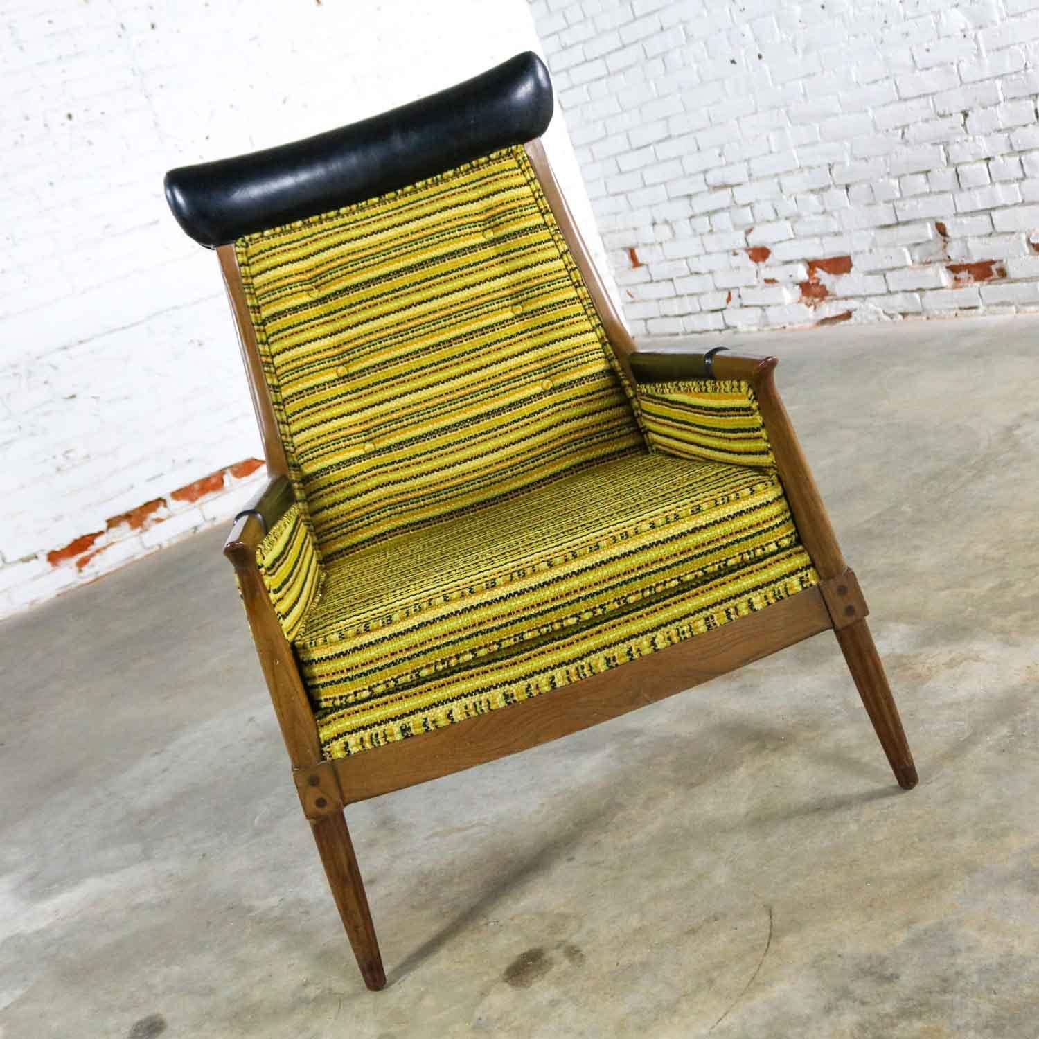 Awesome Mid-Century Modern horn style armchair in its original green, gold, and black striped upholstery with black faux leather accent and wood legs and arms. In wonderful vintage condition. Please see photos. Circa 1950s-1960s.

This exceptional