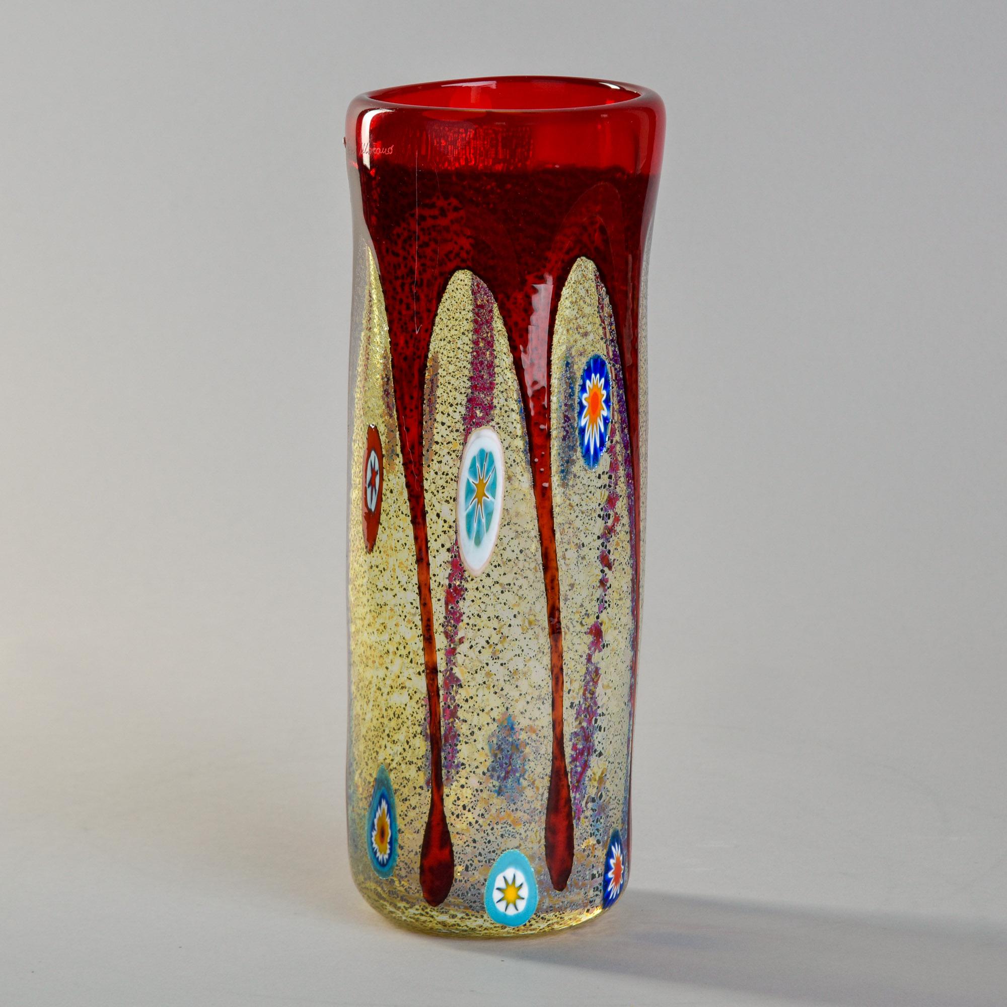 Found in Italy, this Murano glass vase by Imperio Rossi dates from the 1980s. At 11-1/2” tall, this vase features design elements including a clear glass body with blue speckles and murrine glass accents and a wide red “drip” rim. Original Murano