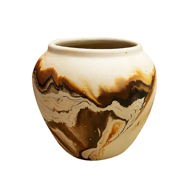A petite small clay roadside touring vase. Glazed on the inside, this vase will be perfect for showcasing a bouquet of your favorite flowers. Handmade, it features swirled clay in a variation of oranges and browns. 

The bottom is marked with an