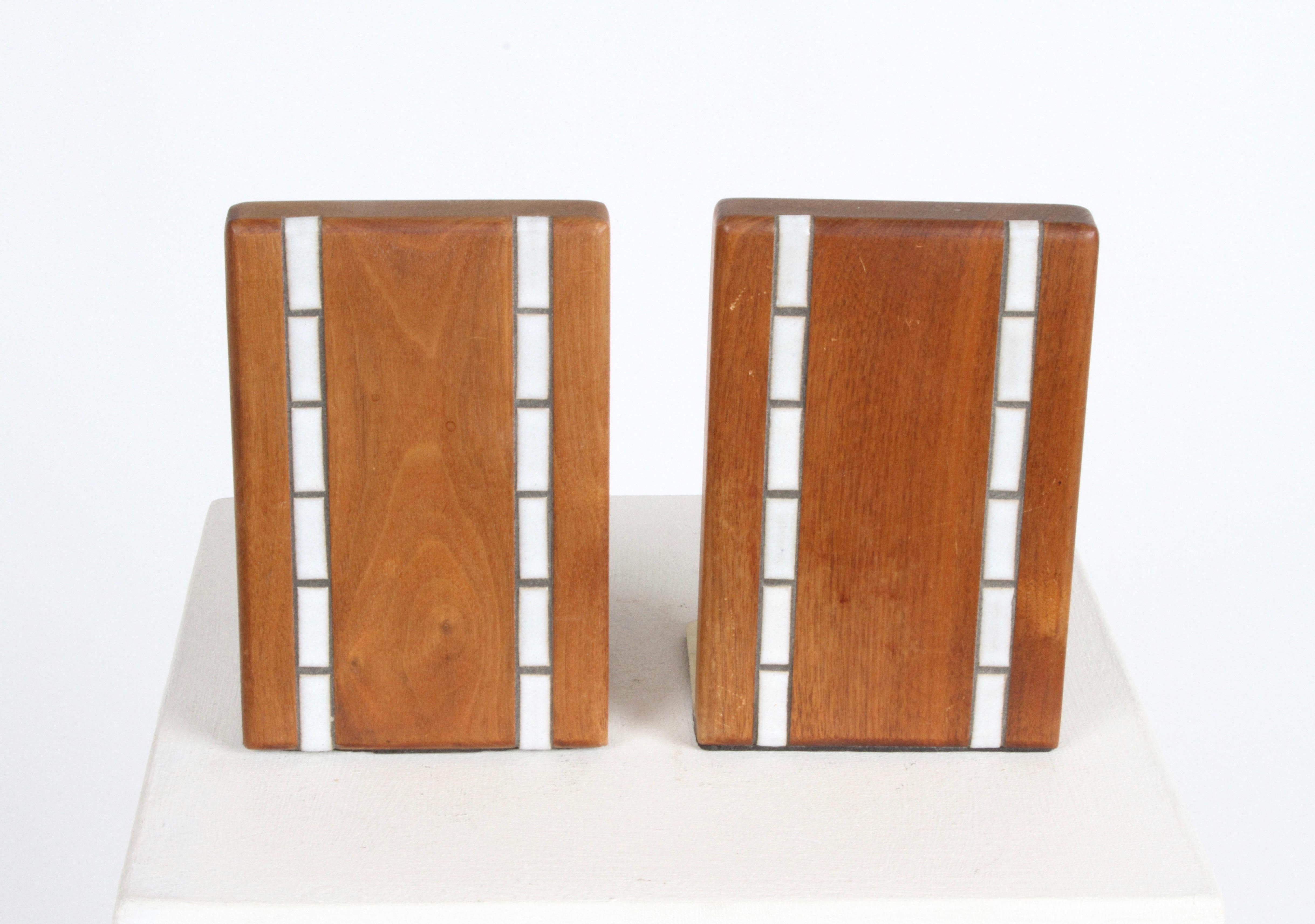 Pair of Mid-Century Modern walnut bookends with vertical white inset tiles by Jane & Gordon Martz for Marshall Studios on brass bases. Very nice original condition.