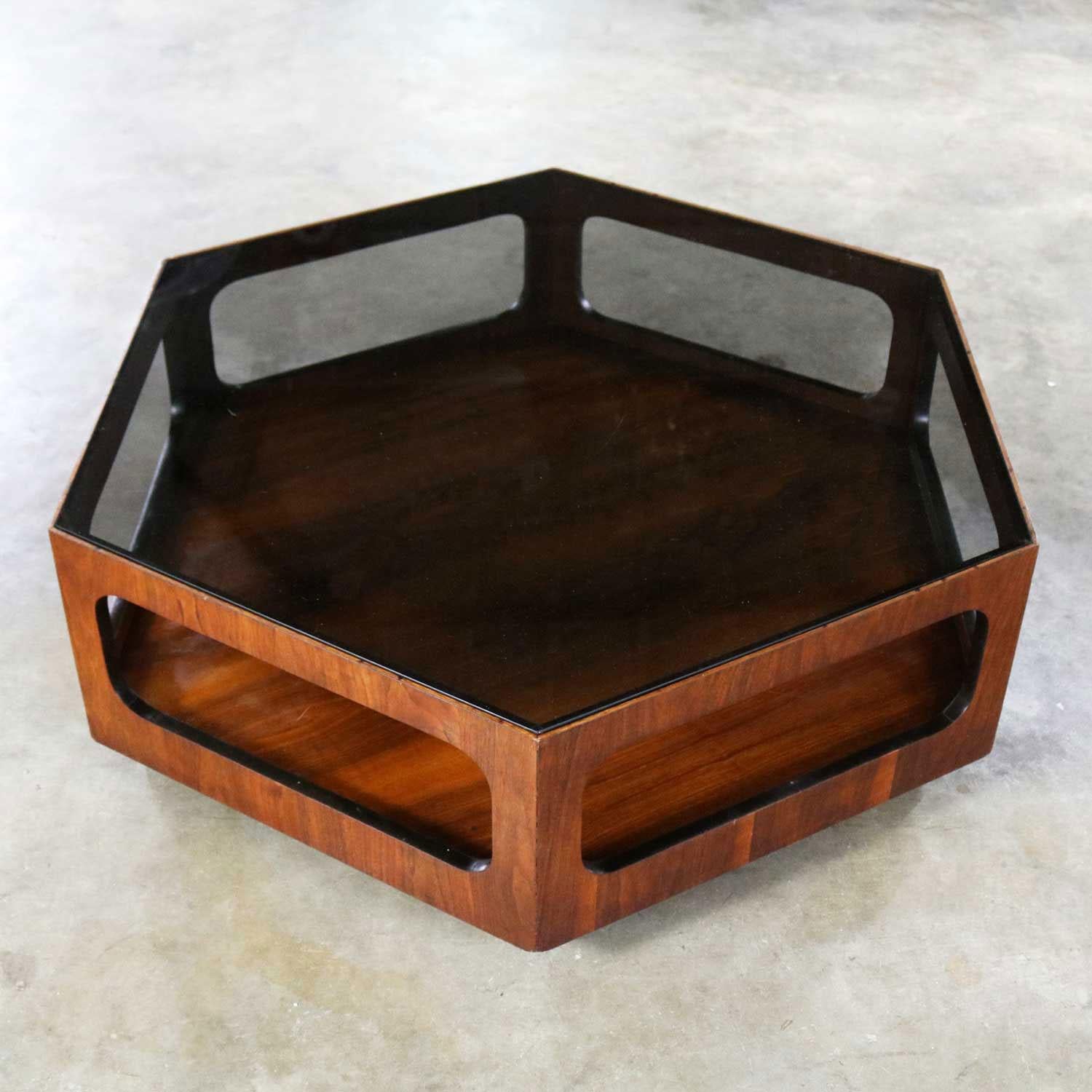 Amazing walnut and smoked glass hexagon coffee table by Lane Alta Vista. This table is marked with the Style No. 1121 04 and its serial no. of 4172120, which dates it to February 12, 1971. It is in wonderful vintage condition. It does have small
