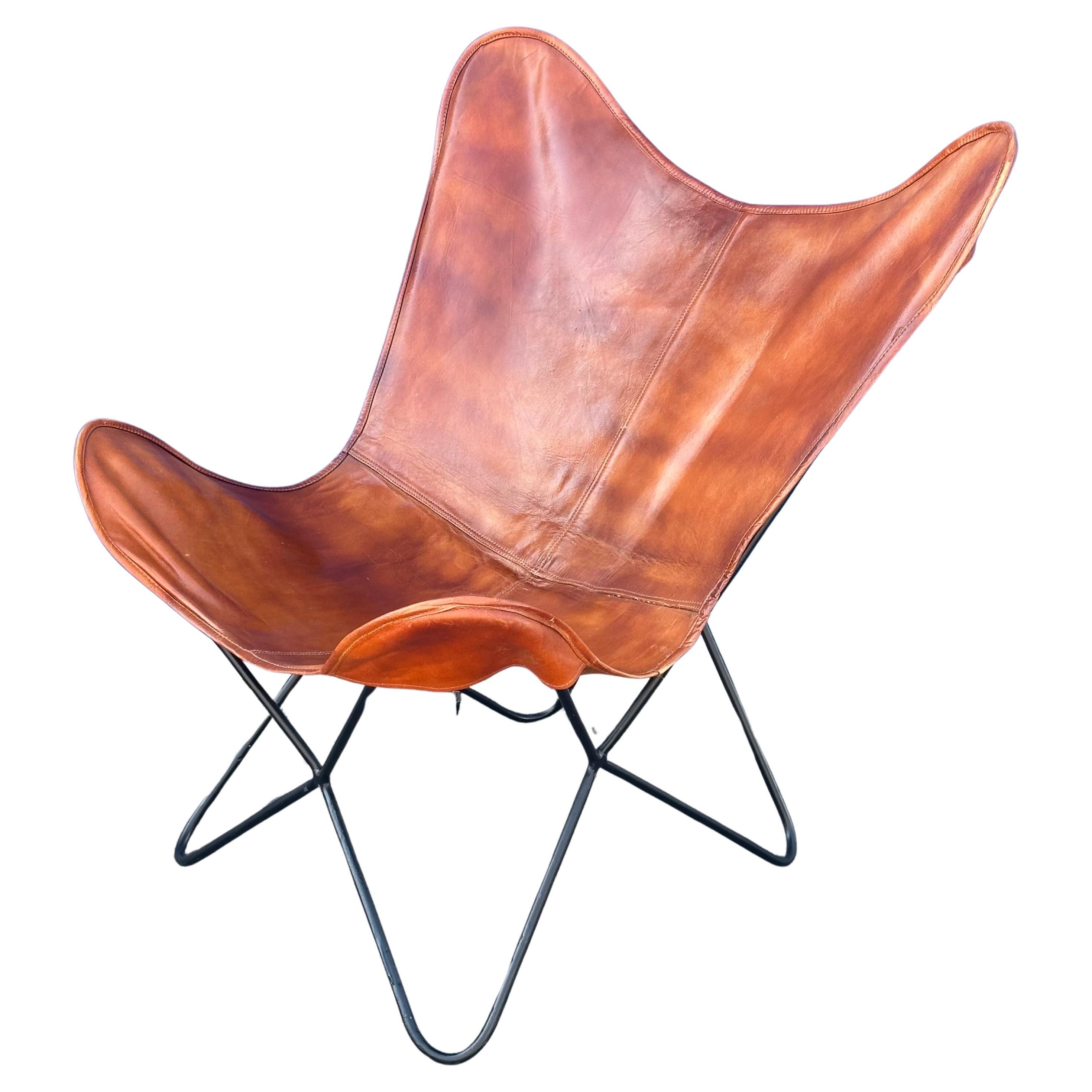 Une chaise papillon en cuir et fer MCM très cool et confortable,  vers les années 1960. La pièce est en très bon état, avec une belle patine. Elle mesure 16 