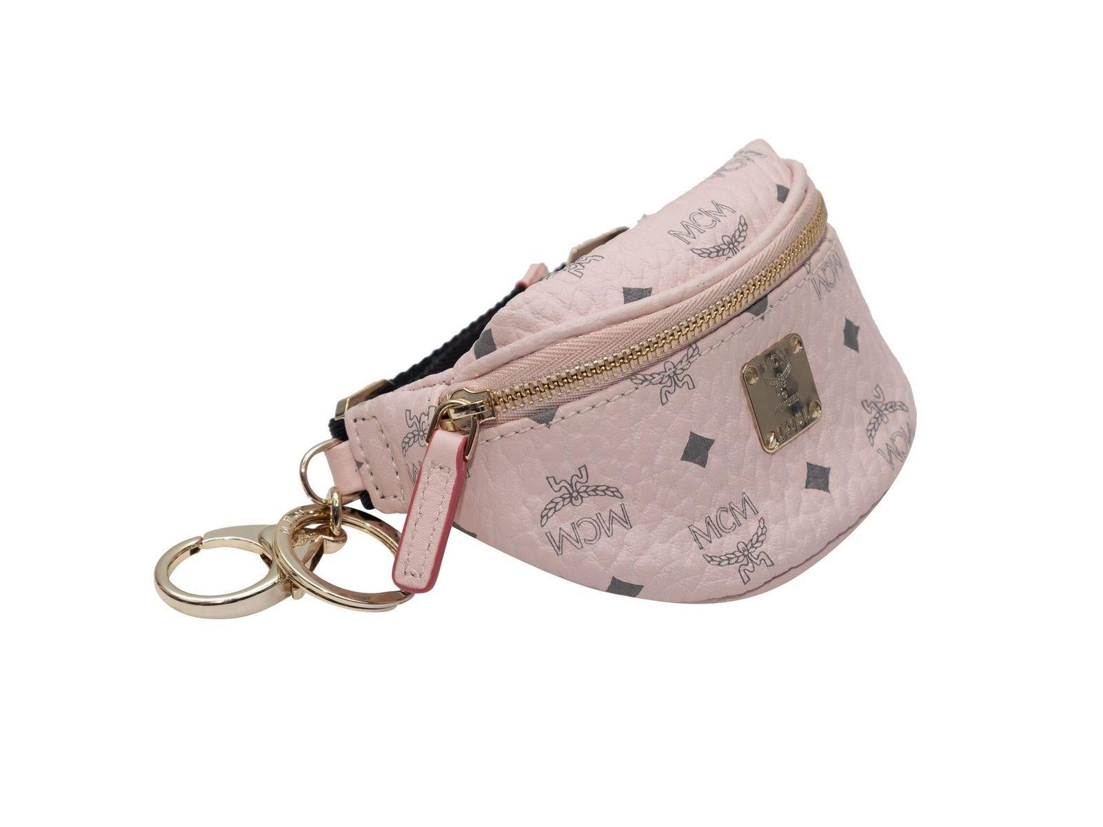Product Details: Light pink visetos mini belt bag key ring by MCM. Gold-tone hardware. Zip closure at front. Key ring clip. 3.5