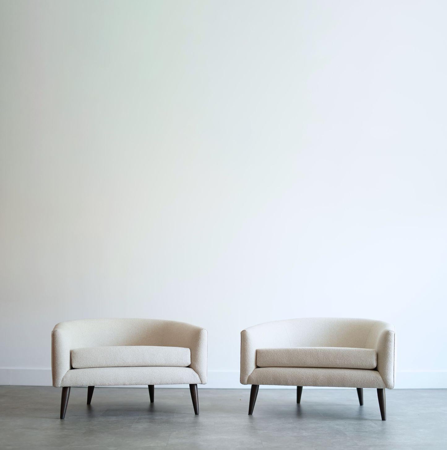A stunning pair of low-profile barrel back lounge chairs in the style of Adrian Pearsall, circa 1950s. Expertly restored by Stamford Modern, they feature elegant curves and inviting proportions. Reupholstered in a soft oatmeal fabric for a timeless