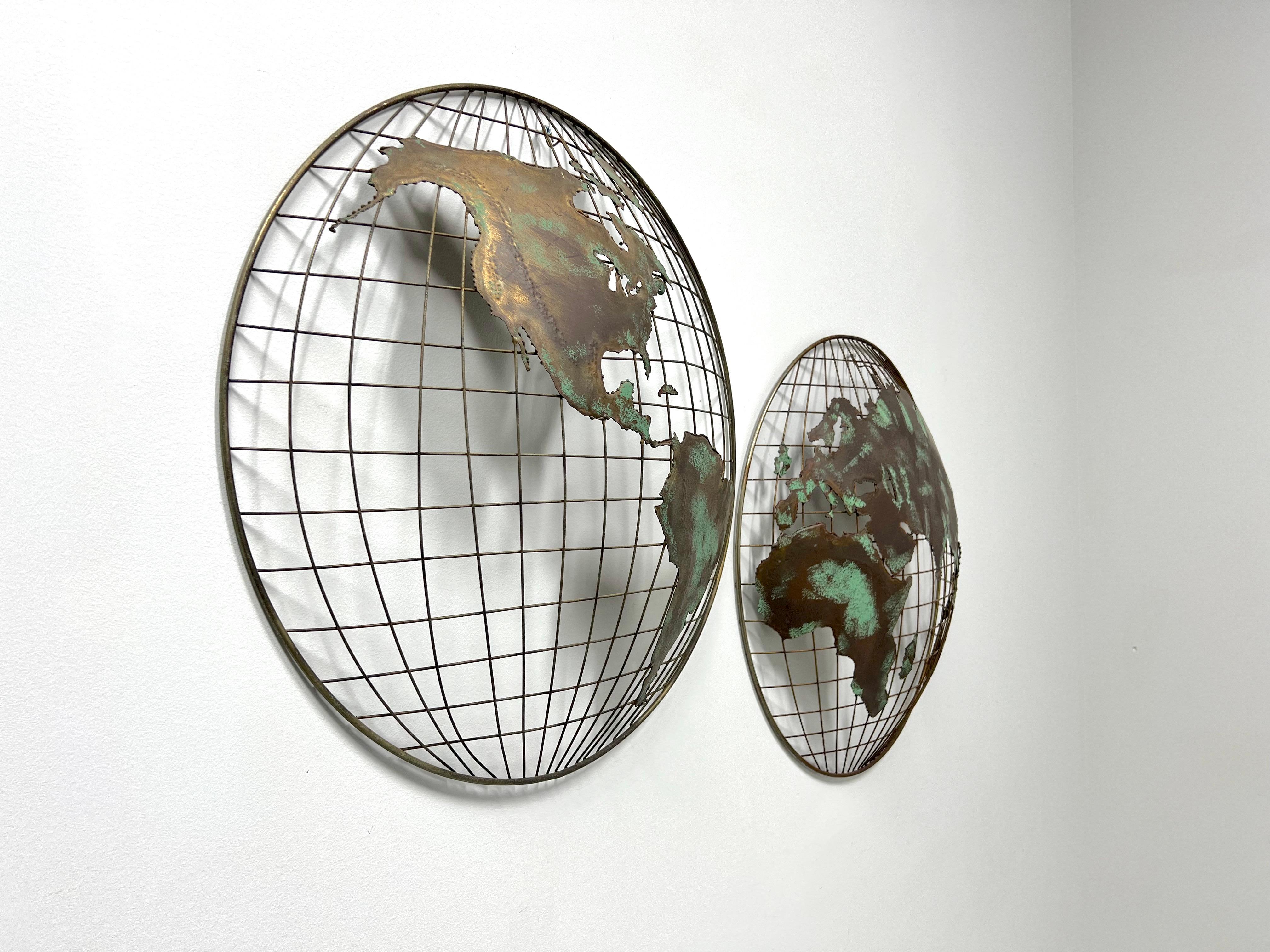 A companion pair of Brutalist style globe hemispheres metal sculptures. Unsigned, in the manner of Curtis Jere. Patinated bronze color solid metal forming the clearly visible continents over open mesh-like metal forming the latitude and longitude