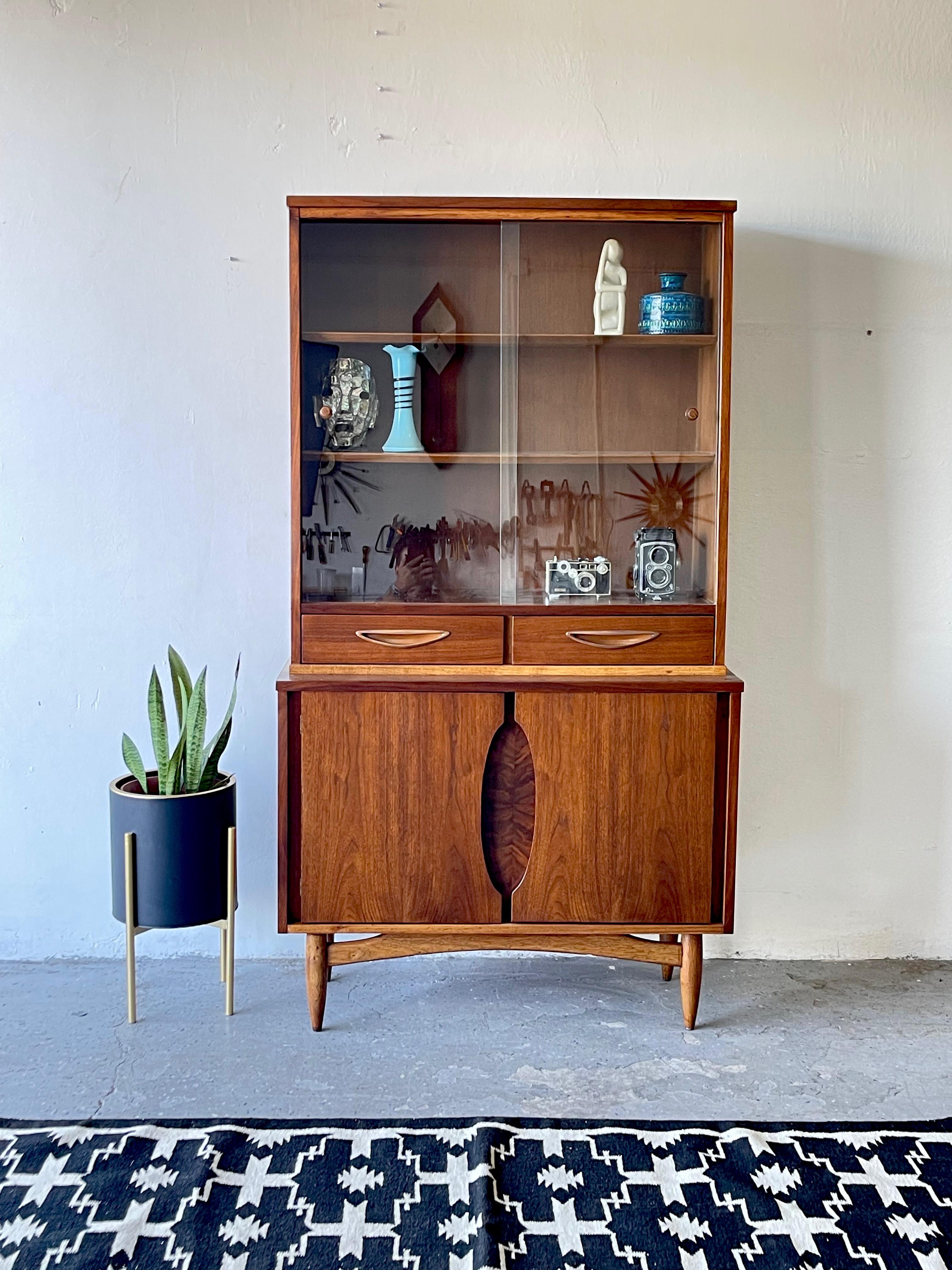 This beautiful Garrison furniture company china display cabinet is made with walnut and has glass sliding doors. It has been Professionally refinished and restored

This cupboard is an excellent example of Mid-Century Modern furniture with a sleek