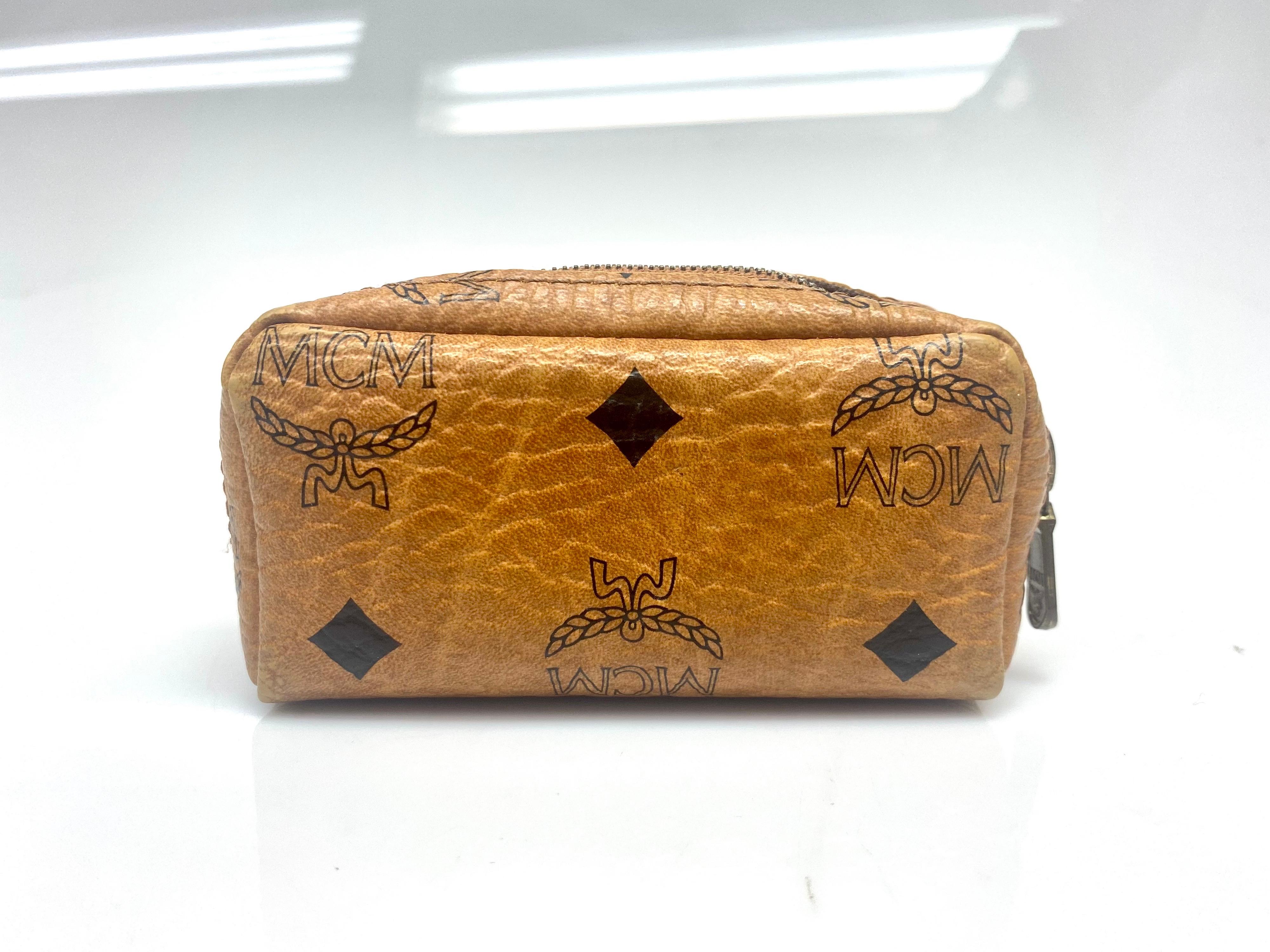 MCM Monogram Tan Coin Purse Keychain. MCM zip pouch in signature Visetos and nappa leather with keychain. This vintage item is in very good condition with small signs of wear.

Dimensions: 

W: 5