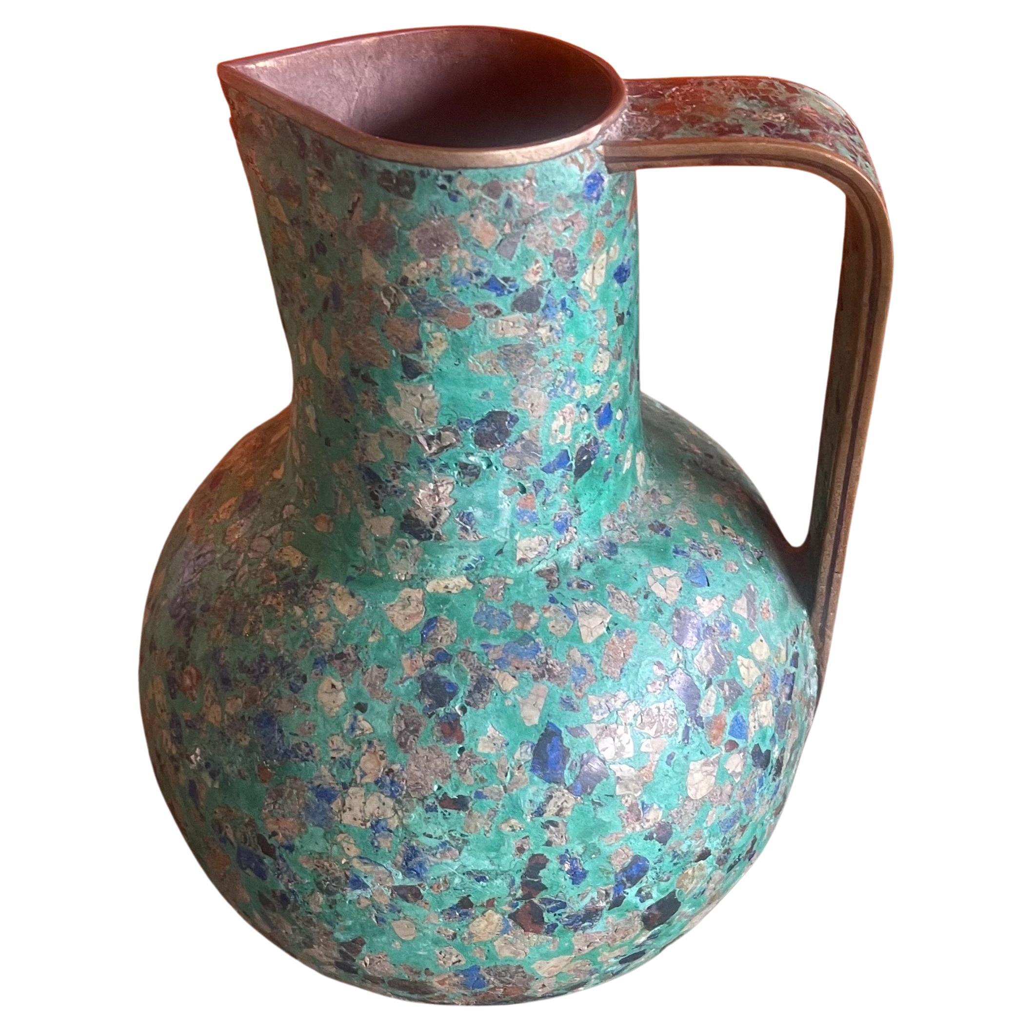 A very unique MCM multi-colored stone on brass ewer or pitcher in the Style of Pepe Mendoza, circa 1970s. The piece is in good vintage condition with a few spots of missing stone (see pictures) and measures 6.5