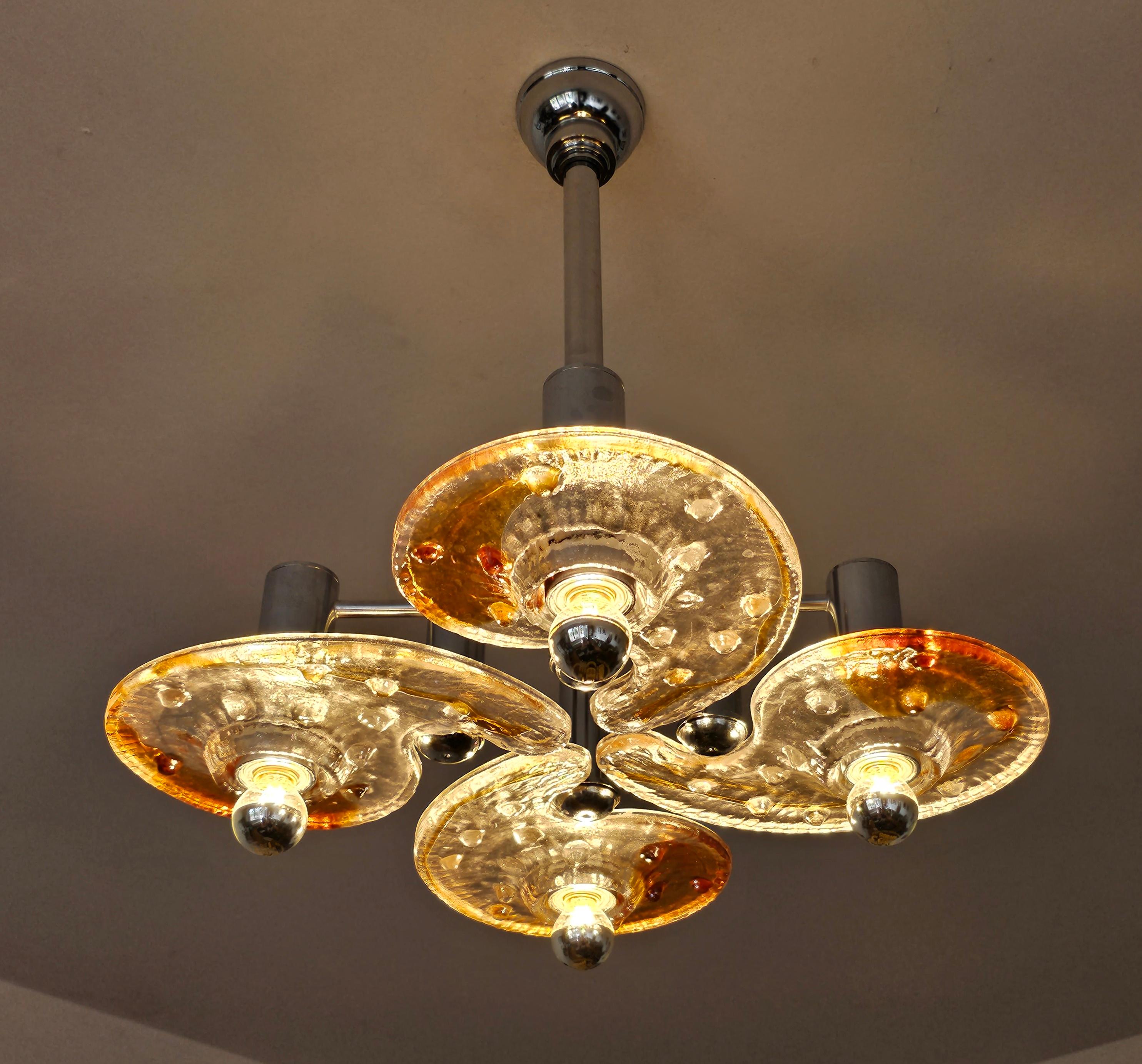 In this listing you will find an extremely rare Mid Century Modern chandelier done in hand molded and fused dark amber and clear Murano glass plates in organic shape. This chandelier was designed by a renowned designer Carlo Nason for the MAZZEGA