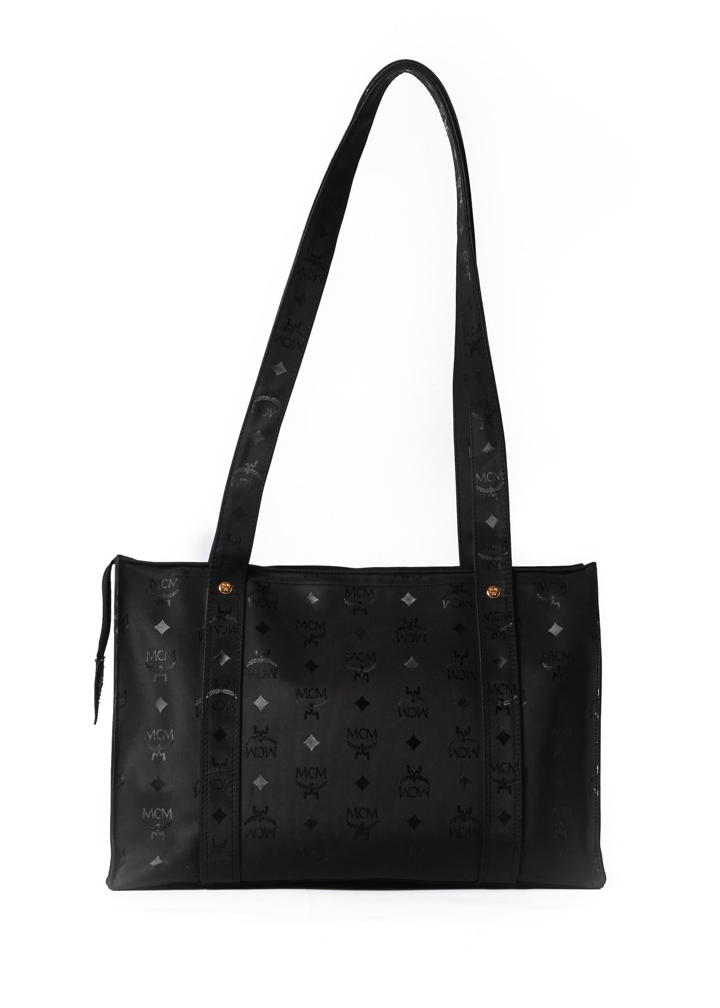 This MCM tote bag is made with black nylon. Waterproof. Features gold hardware, dual load flat shoulder straps, front slip pocket and a large spacious interior.

COLOR: Black
MATERIAL: Nylon and leather trim
ITEM CODE: M8296
MEASURES: H 10” x L 15”