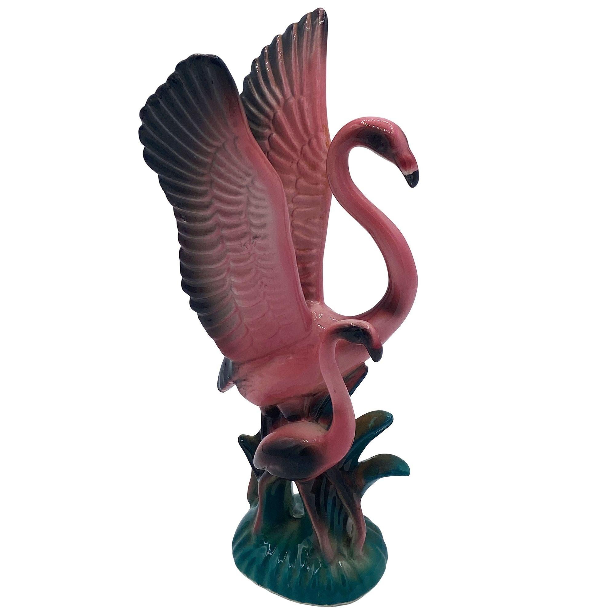 Mid-century pink and green ceramic open-wing mother flamingo tabletop pottery statue by Leftons. The statue features a beautifully detailed pink flamingo mother with her child. It comes in a gloss finish that highlights the rich pinks, greens, and