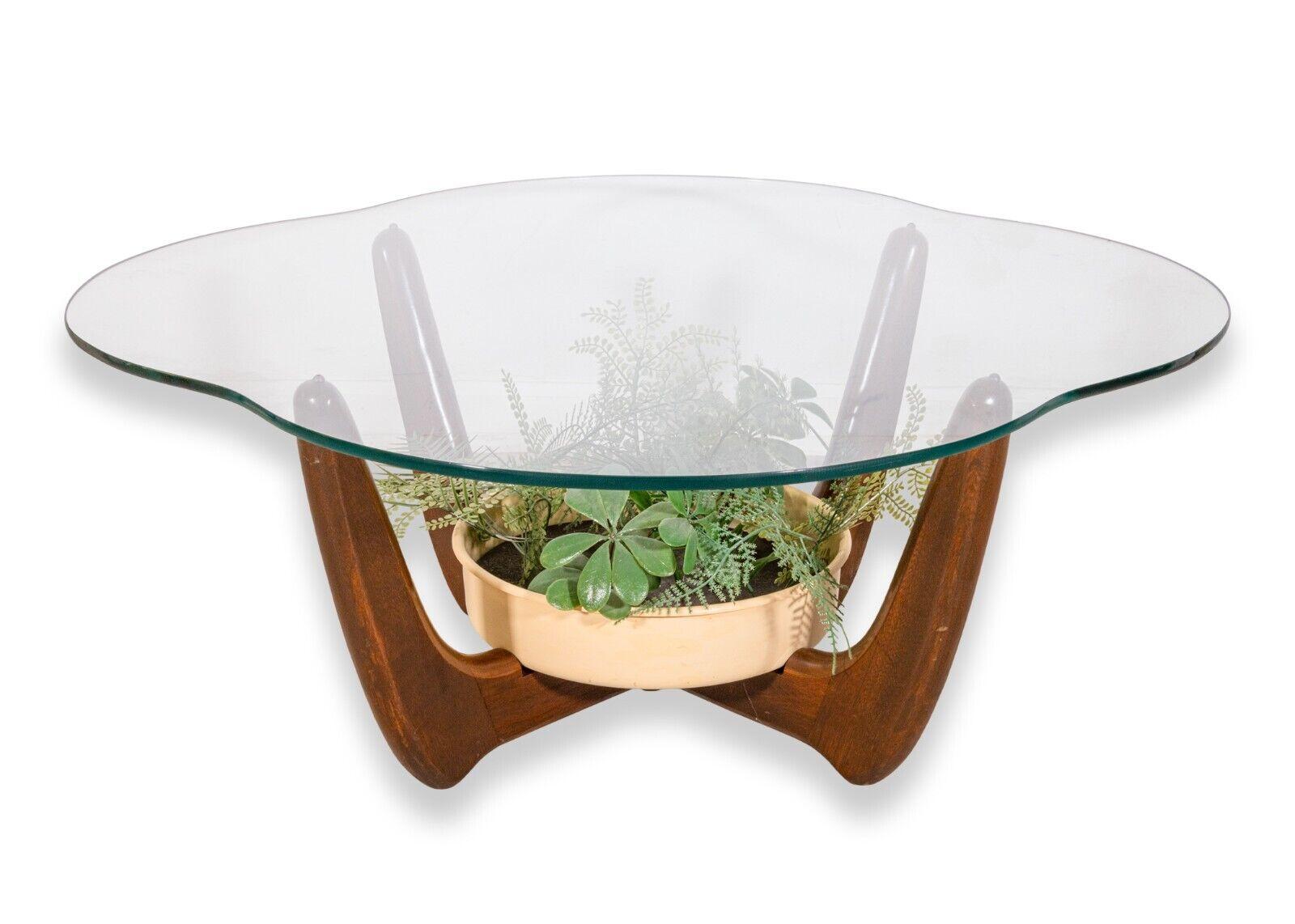 A mid century modern pair of Pearsall style sculptural base side and coffee tables with planters. This is a gorgeous set of complimentary tables. Both tables feature a full walnut construction, glass table tops, and round plastic planters. The