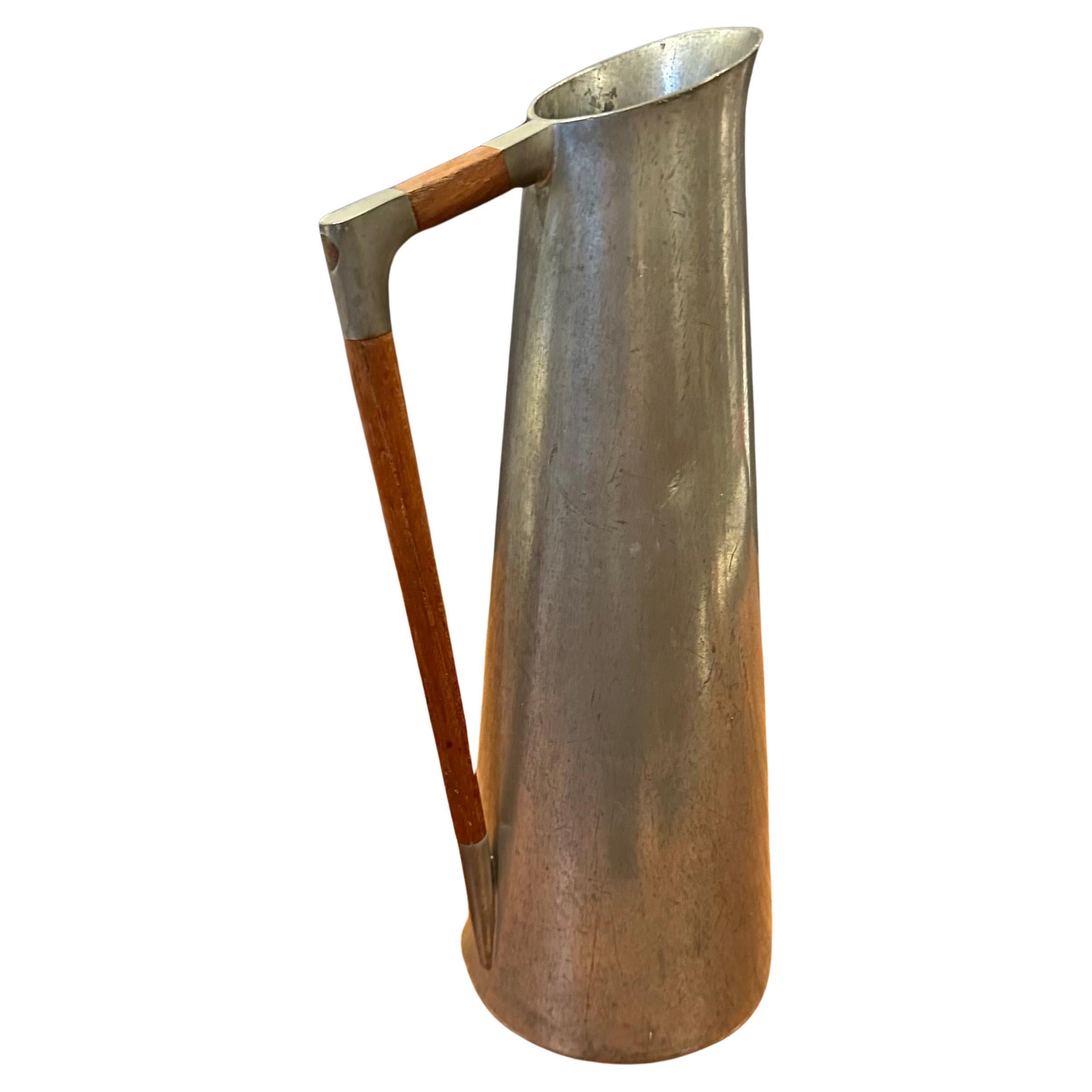 MCM pewter carafe / pitcher with teak handle by K.M.D Tiel Royal of Holland, circa 1960s.  The piece is in good vintage condition with a nice patina and measures 5