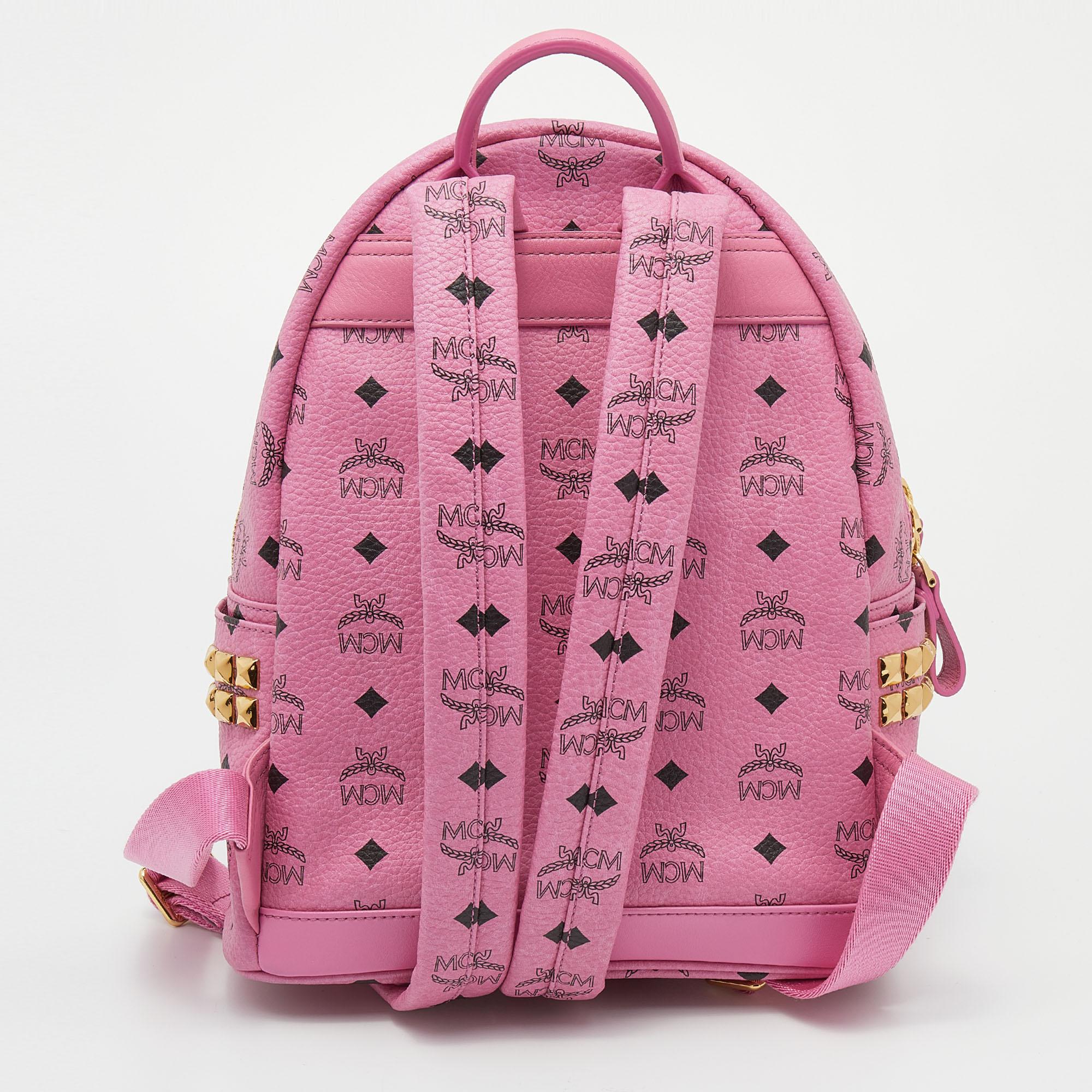 This pretty MCM backpack will come in handy for daily use or as a style statement. It is crafted from coated canvas and designed with stud embellishments, a front pocket, and a spacious interior secured by a zipper. Two shoulder straps and a small