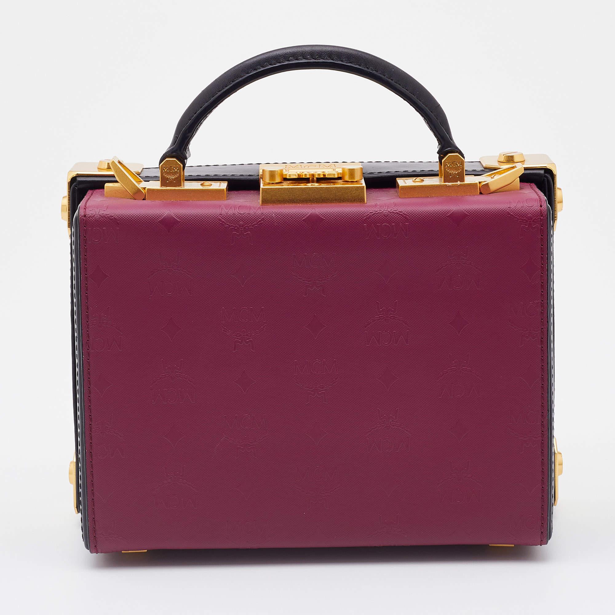 This pretty bag from MCM is a treat to our eyes! The box-shaped bag is made from coated canvas and leather and is decorated with striking gold-tone accents. A top handle reveals the well-sized interior of the bag, and a detachable shoulder strap is