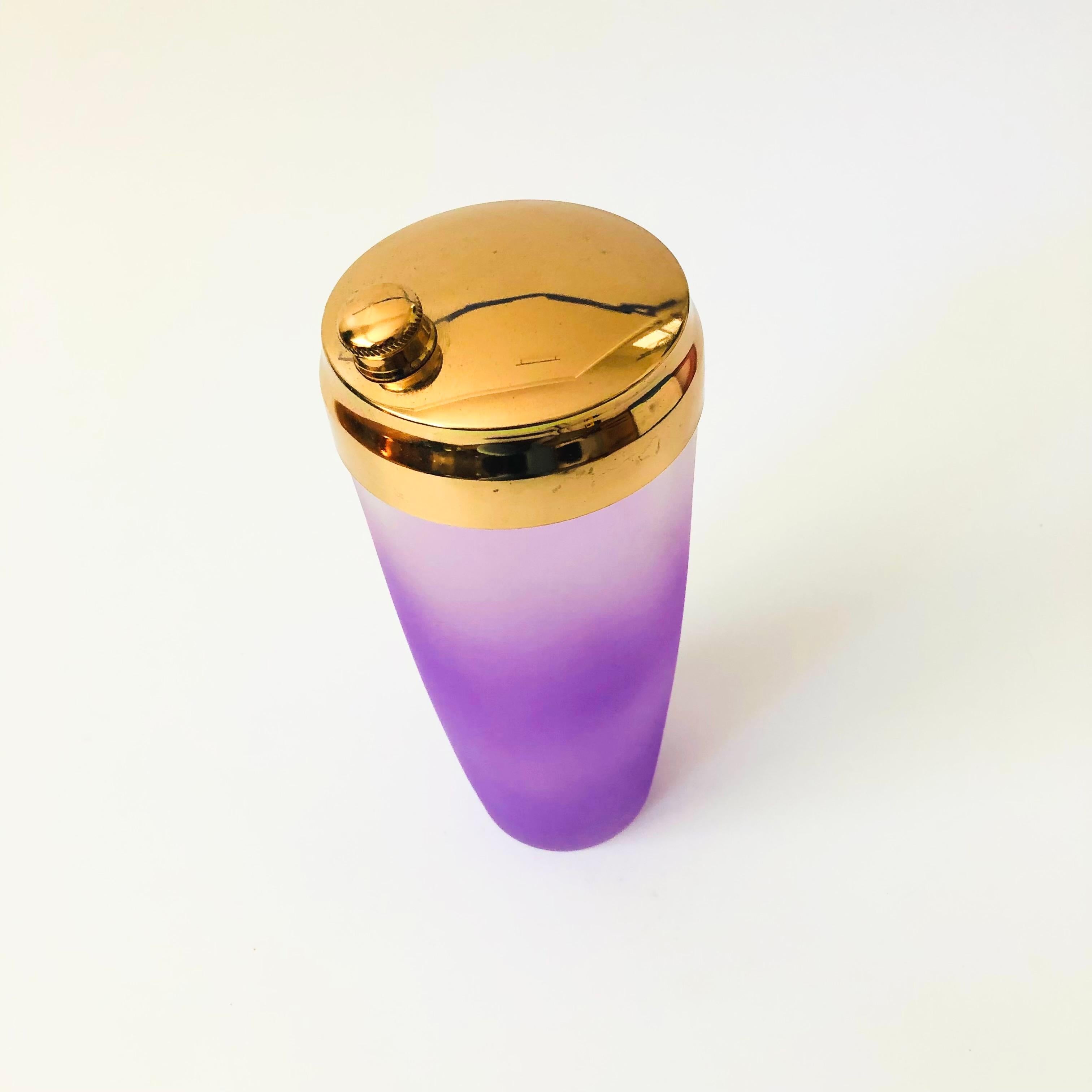 A  mid century glass cocktail shaker. Beautiful purple blendo coloring to the glass the fades from bright purple at the base to clear at the top. Topped off with a gold tone metal cap.




