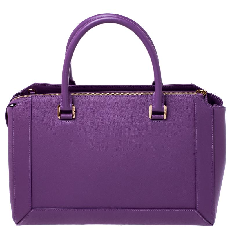 This creation from MCM has a modern design with a leather exterior covered in purple and a fabric interior secured by a zip closure to safely carry the things you cannot do without. Held by two top handles and a detachable shoulder strap, this tote