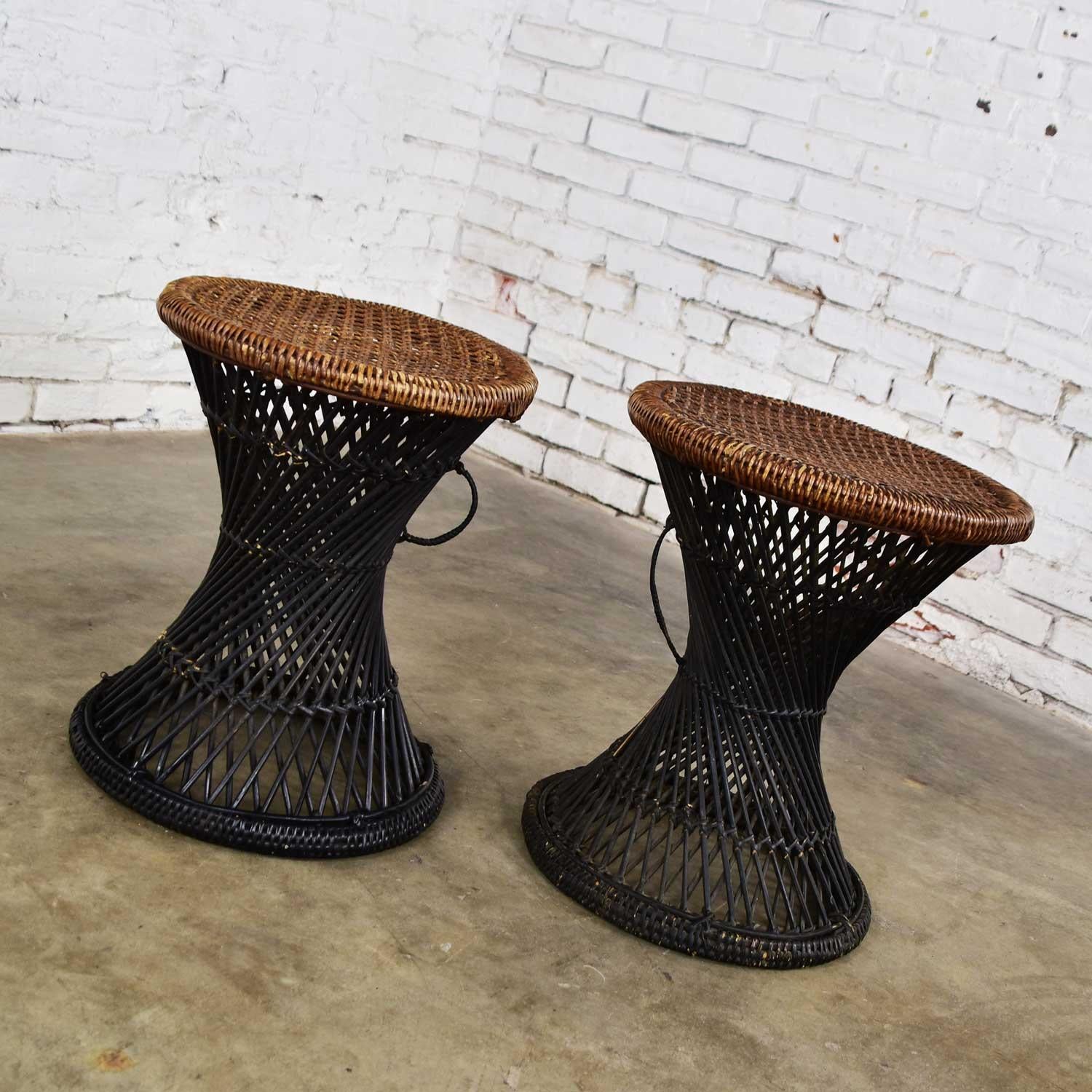 Wonderful pair of Mid-Century Modern rattan and cane cinched waist tables or stools. Beautiful vintage condition. They have been cleaned, a few small repairs made to the rattan wrappings, the bottom ring on one of the pieces was repainted black