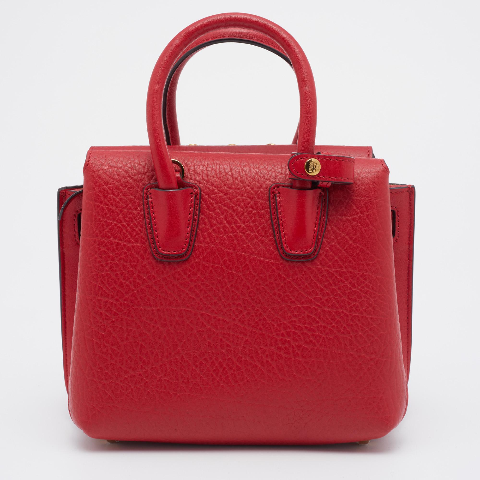 This gorgeous Milla satchel comes from the House of MCM. It is crafted from red leather on the exterior, which flaunts crystal embellishments on the front. It features two handles, gold-toned hardware, and a suede-lined interior. This stunning MCM
