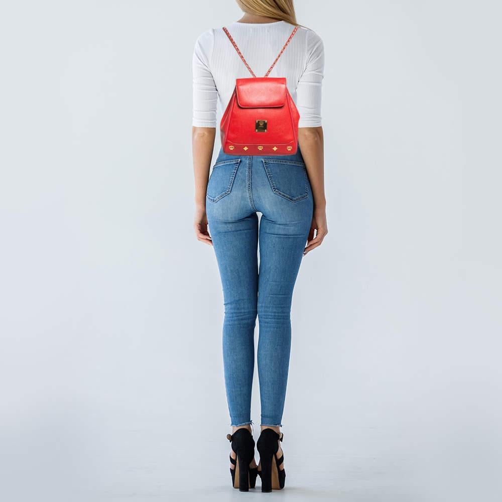 This red MCM backpack is made from high quality leather in a functional design. It has a flap closure and gold tone metal fittings.