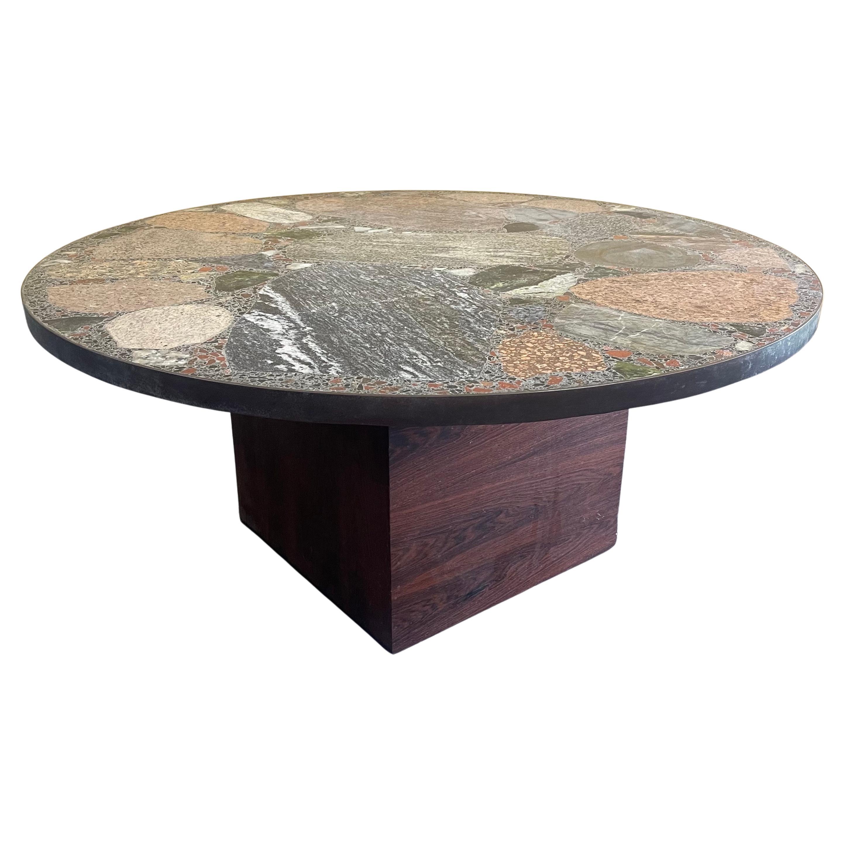 A gorgeous round terrazzo top coffee table by Erling Viksjo for A.S. Conglo, circa 1960s. The table is made of various Norwegian stones and concrete with a thin brass band and sits on a wooden cube. Viksjø was a Norwegian architect and designer best