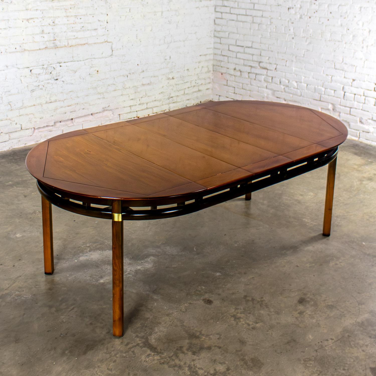 Handsome vintage MCM (a.k.a. Mid-Century Modern) to Campaign style round to oval expanding dining table attributed to the Tung-Si collection by Hickory Manufacturing. This piece has been attributed based upon archived research including online