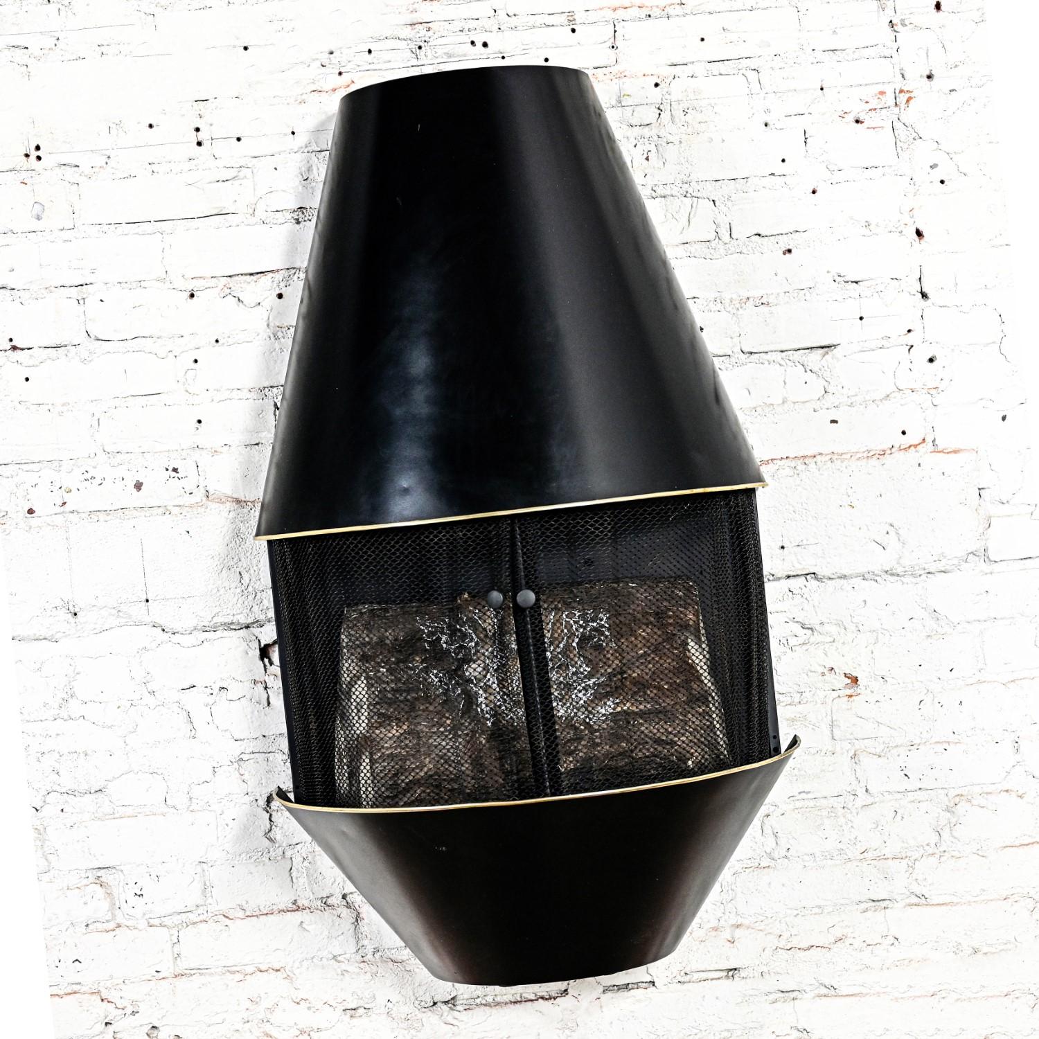 Incredible vintage Mid-Century Modern electric wall fireplace Model #41152 with a black painted frame, brass plated trim around the opening, black mesh screen & artificial logs. Beautiful condition, keeping in mind that this is vintage and not new