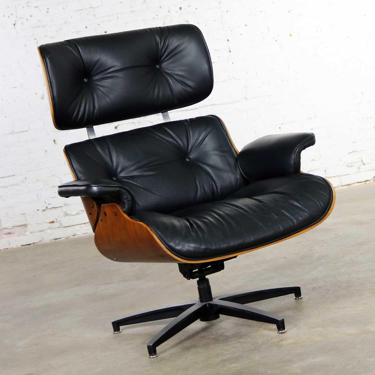 Handsome Selig black vinyl and walnut Mid-Century Modern lounge chair in the style of the famed Eames lounge chair by Herman Miller. It is wonderful vintage condition overall. There are some nicks and dings to the wood and a couple small blemishes