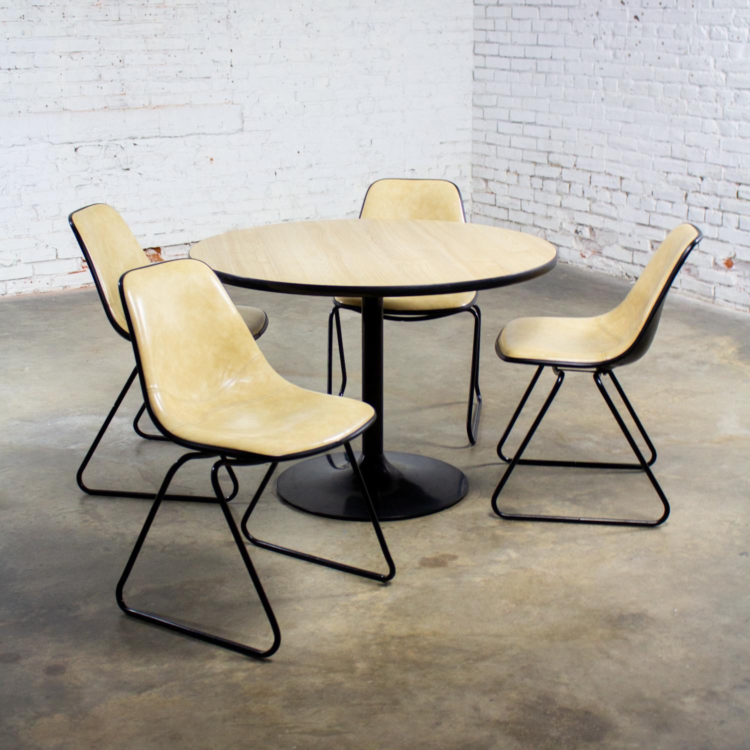 Wonderful vintage Mid-Century Modern set of 4 Krueger chairs of molded fiberglass shell bodies with seats & backs of mottled creamy beige Naugahyde upholstery, and black painted sled style bases, combined with a round table that has a light faux