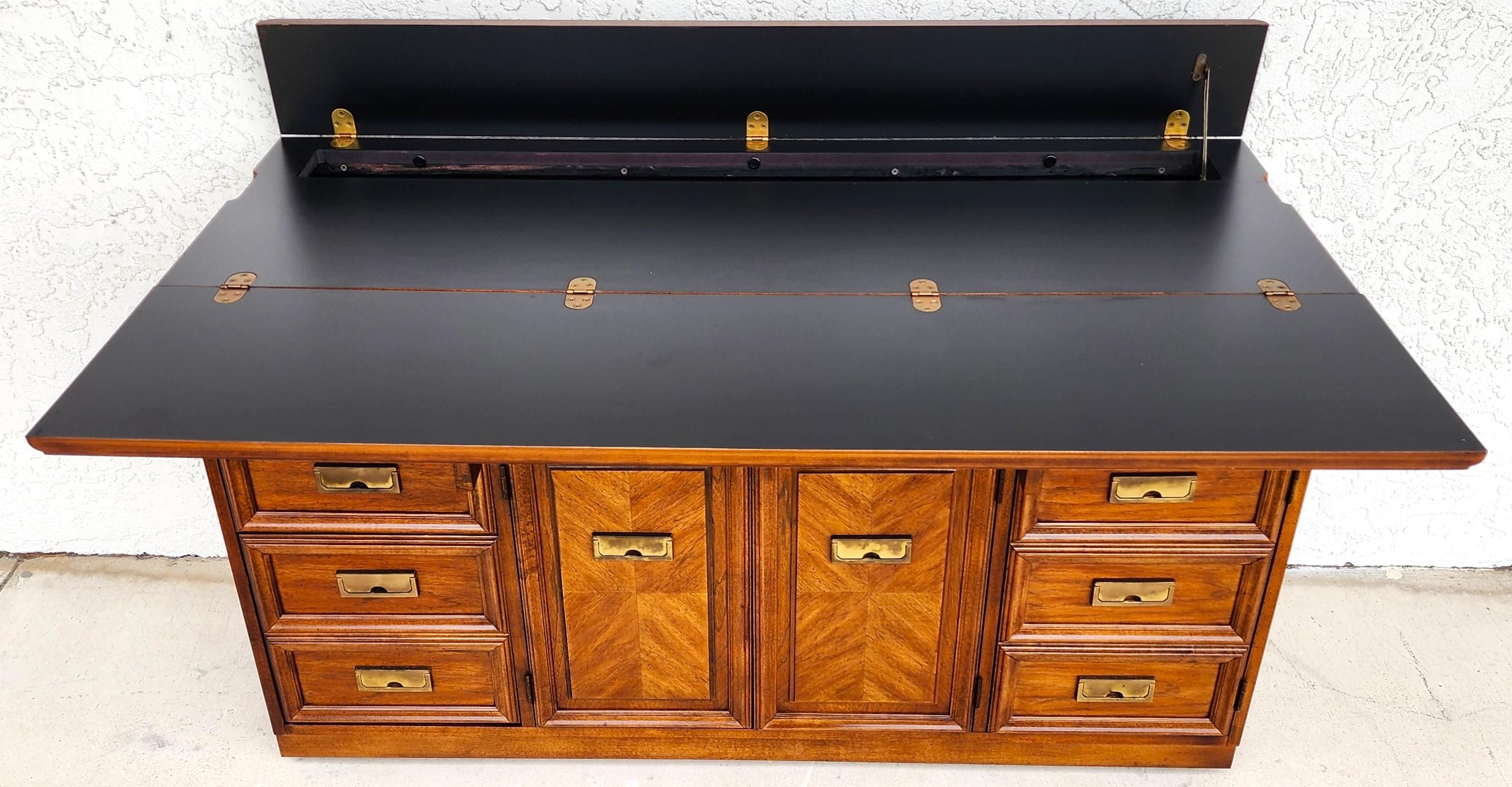For FULL item description click on CONTINUE READING at the bottom of this page.

Offering One Of Our Recent Palm Beach Estate Fine Furniture Acquisitions Of A
Vintage 1970s MCM Campaign Style Flip Top Rolling Sideboard Bar Buffet by