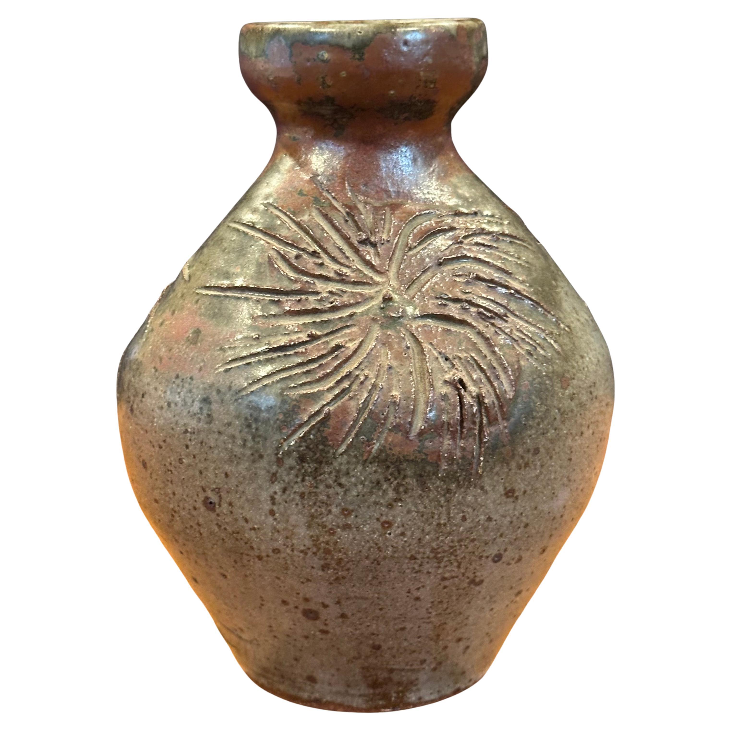 A very nice MCM signed California studio pottery stoneware vase with sunbursts, circa 1960s. The vessel is in very good vintage condition with no chips or cracks and measures 5.75