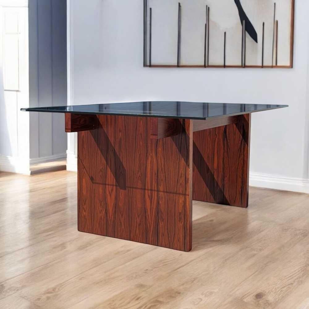 Un tavolo da pranzo distintivo nella tradizione scandinava di metà secolo, realizzato con una ricca impiallacciatura di palissandro e dotato di un piano in vetro trasparente che mette in risalto l'eleganza scultorea della sua base minimalista.