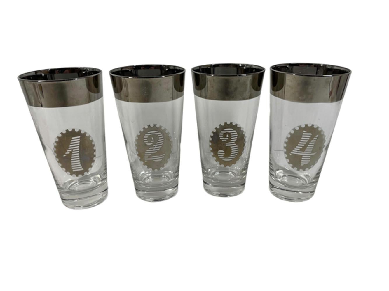 Set of eight highball glasses numbered 1 to 8 having wide silver rims and oval medallions with stylized numerals in the center.
